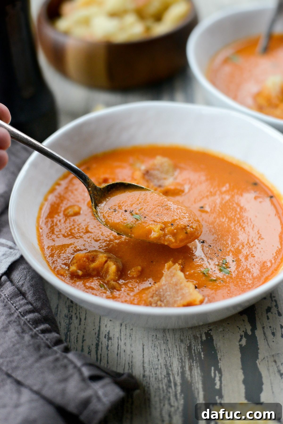 A stunning final presentation of Homemade Roasted Red Pepper Tomato Soup, garnished with a sprinkle of fresh herbs.