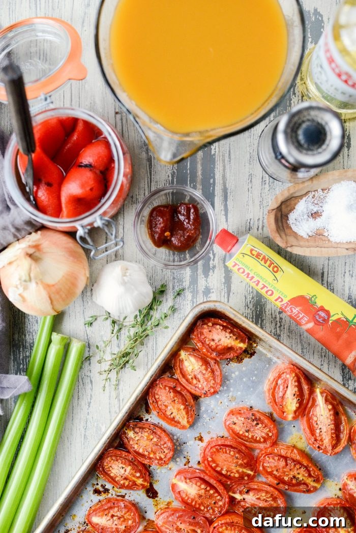 All the fresh ingredients for Roasted Red Pepper Tomato Soup laid out on a wooden cutting board.