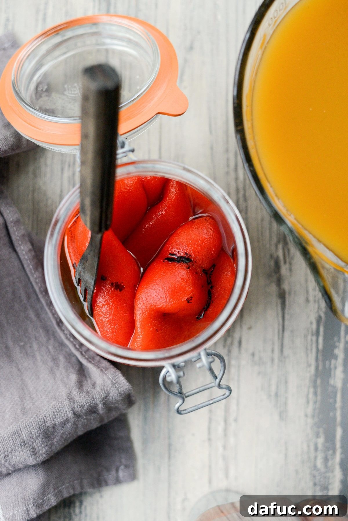 Jar of perfectly roasted red bell peppers, glistening in olive oil, ready to be added to the soup.