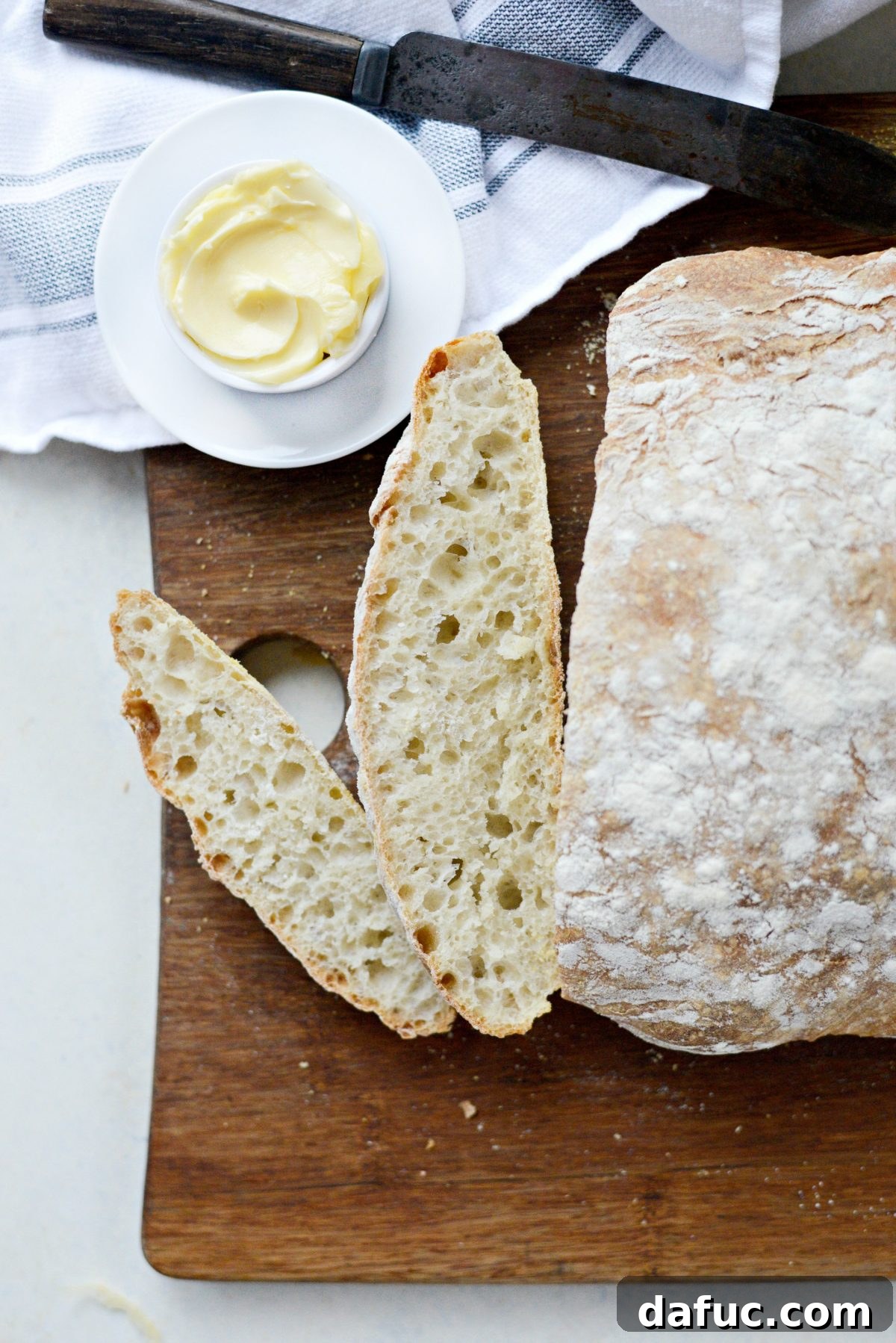 No-Knead Ciabatta: Easy Homemade Perfection 2 Perfectly baked Homemade No-Knead Ciabatta Bread on a cutting board, ready to be sliced