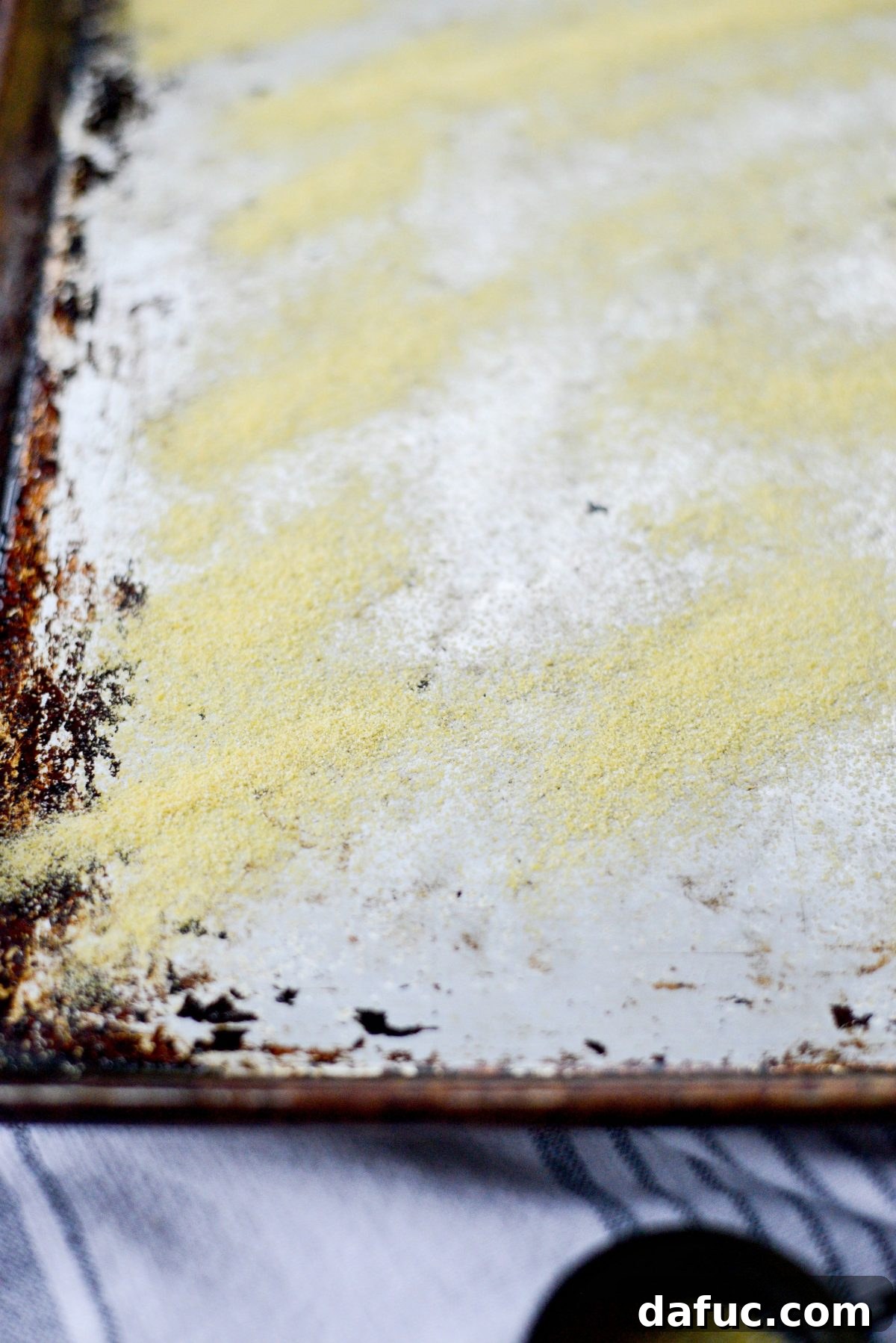 No-Knead Ciabatta: Easy Homemade Perfection 12 Dusting a baking sheet with cornmeal for ciabatta bread