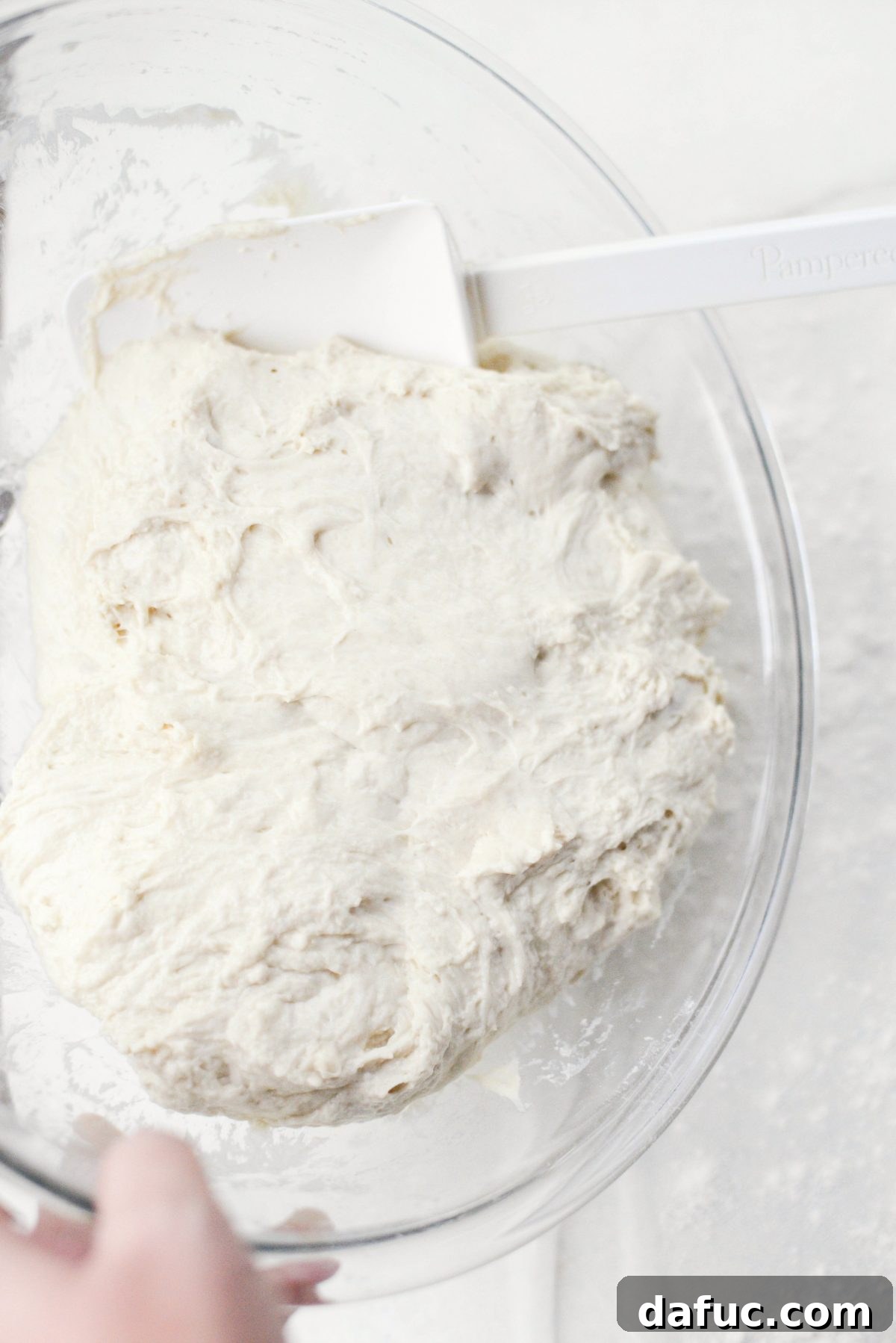 No-Knead Ciabatta: Easy Homemade Perfection 15 Scraping the risen ciabatta dough onto a floured plastic wrap surface