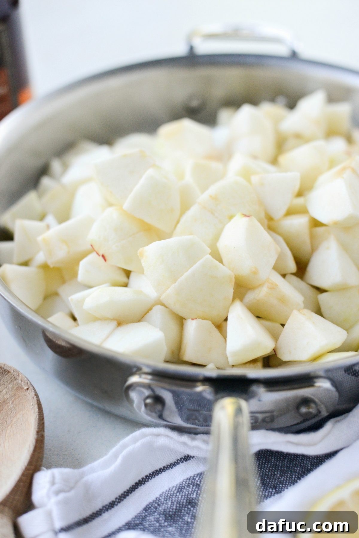 Diced apples ready to be cooked in a skillet for homemade applesauce.