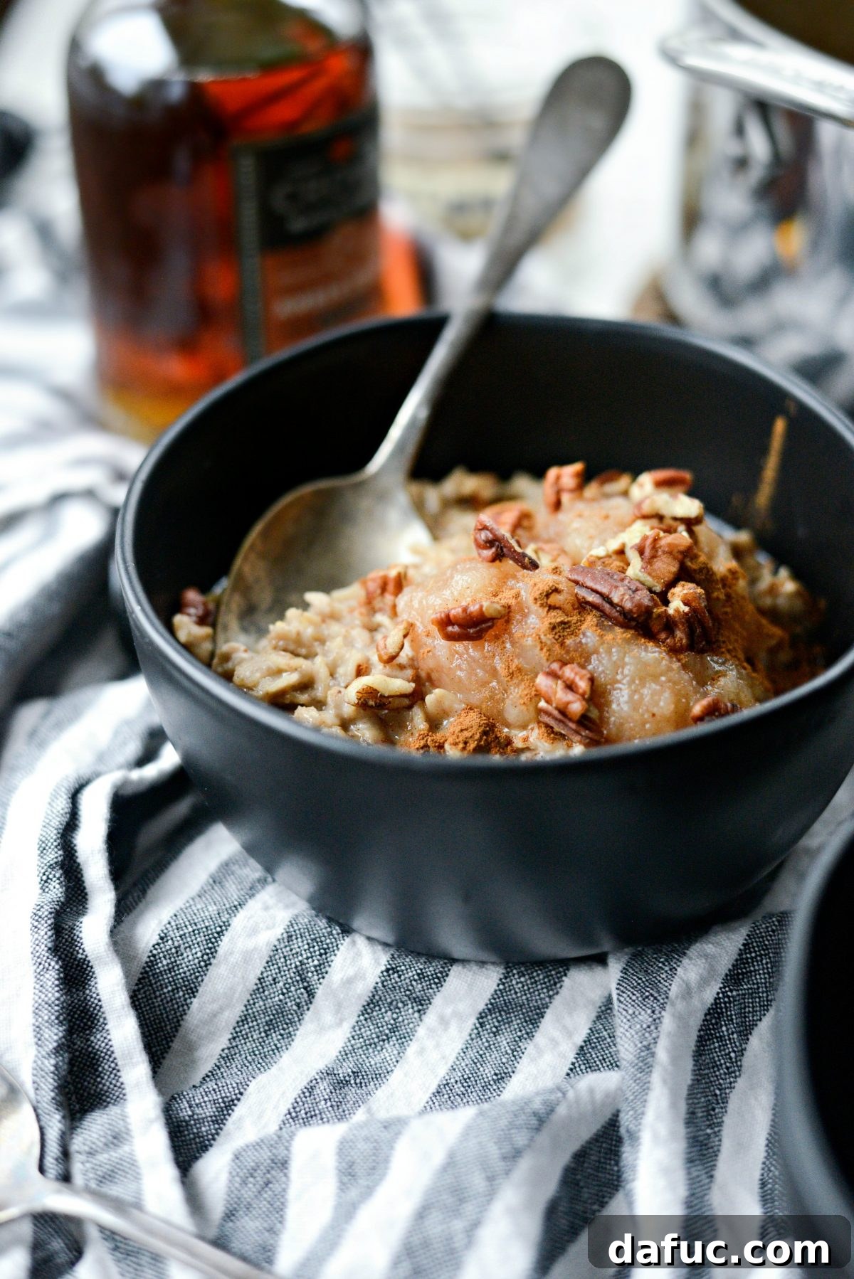 A close-up shot of the finished Apple Chai Oatmeal, garnished with apple slices and pecans, ready to be enjoyed.
