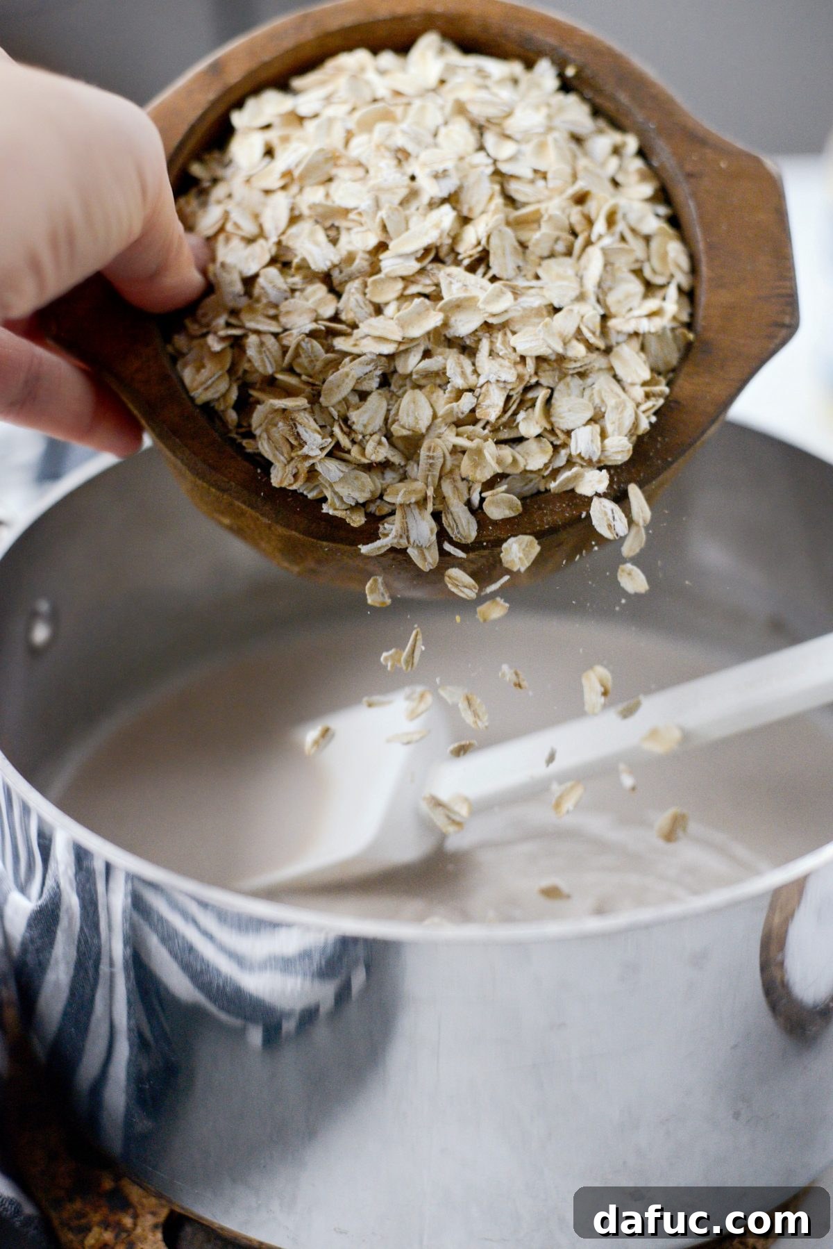 Adding old-fashioned rolled oats to the simmering chai-spiced milk.