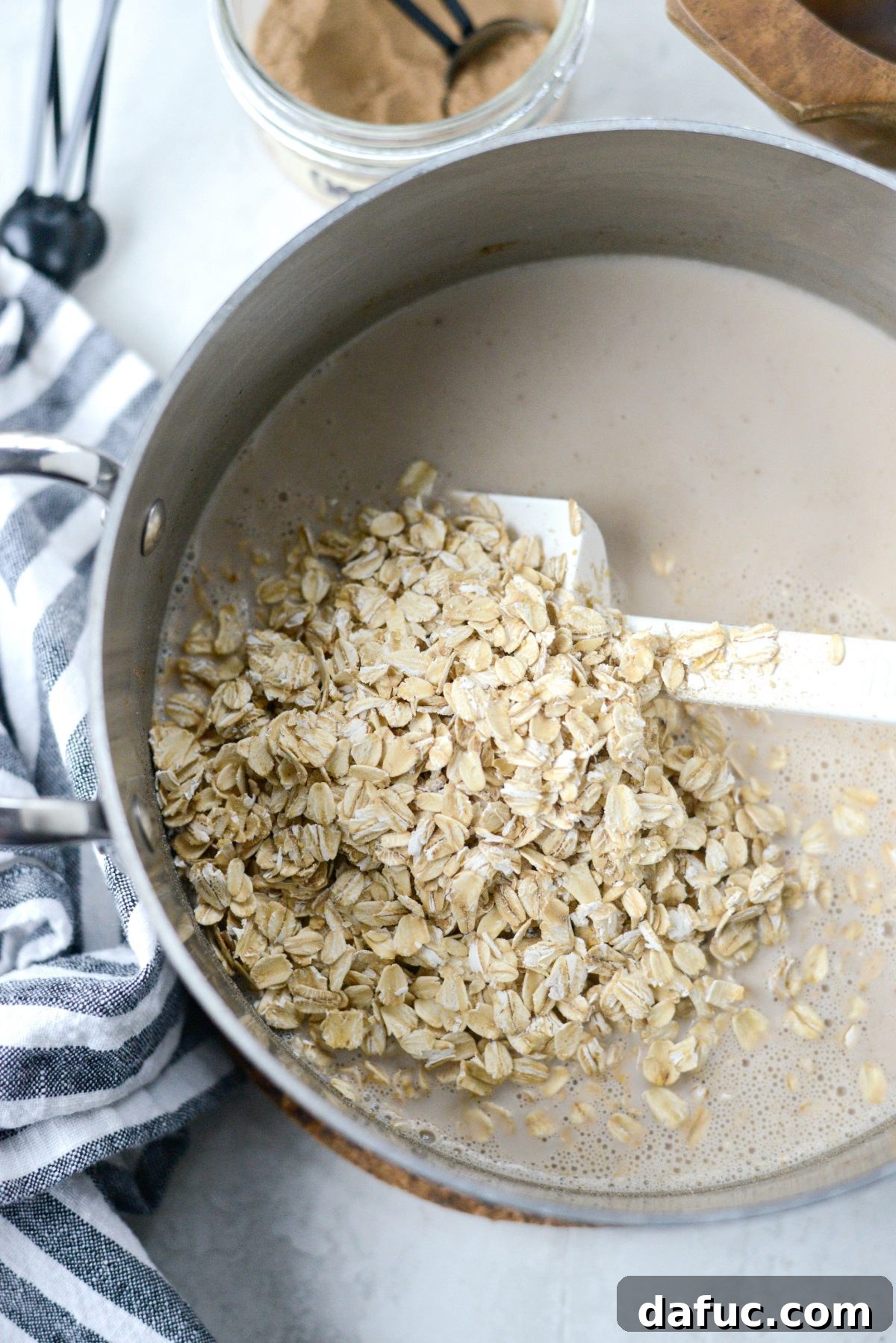 Continuously stirring the oatmeal mixture as it cooks and begins to thicken.