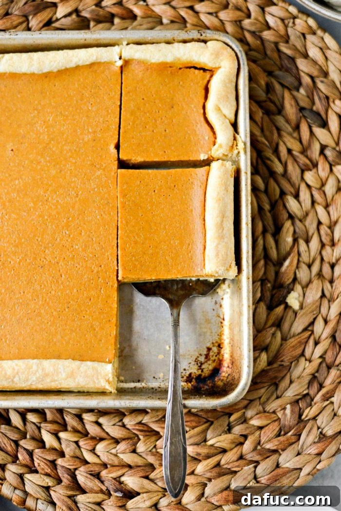 Sheet Pan Pumpkin Pie 17 A delightful slice of Pumpkin Slab Pie topped with whipped cream, accompanied by a cup of coffee