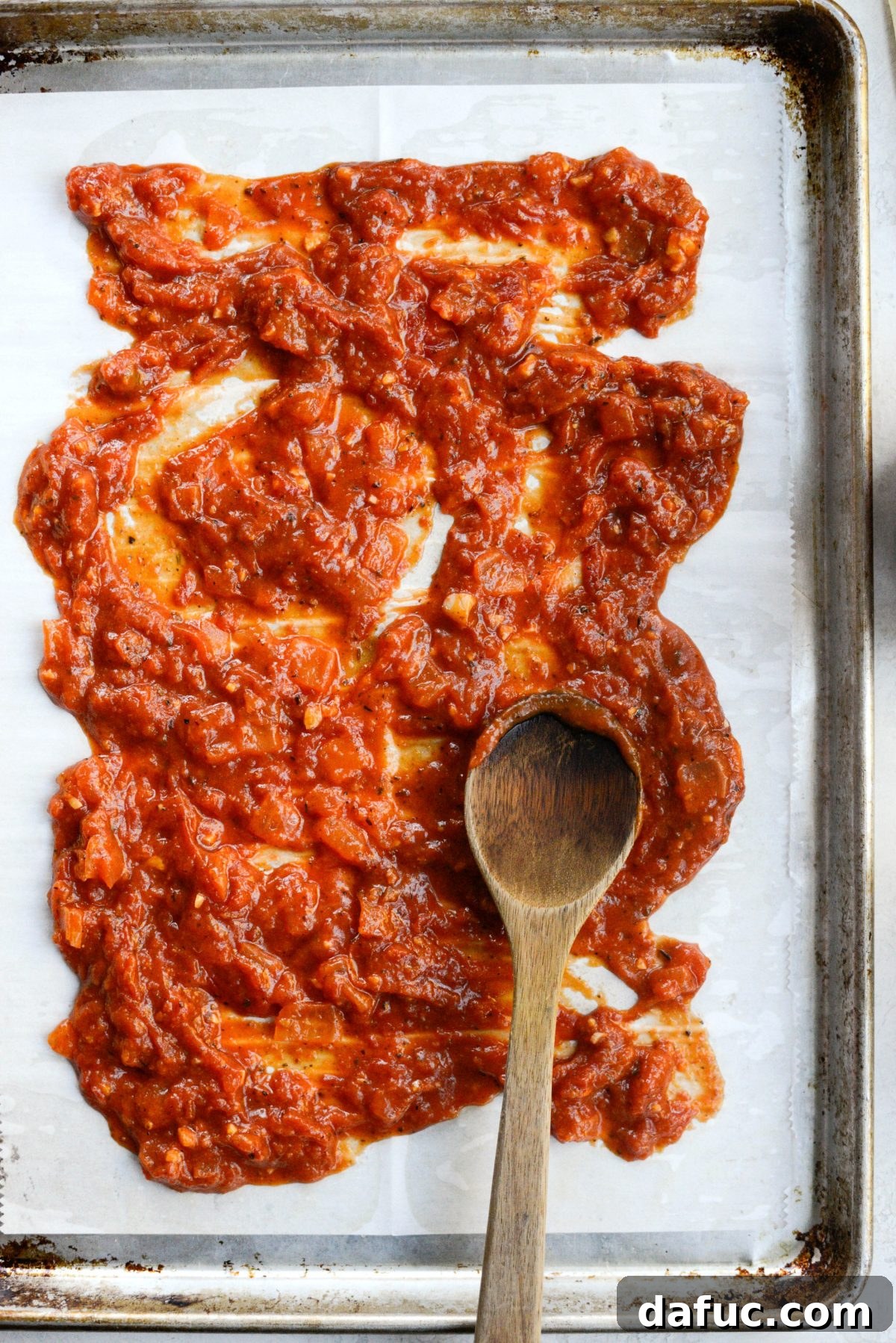 spread sauce on rimmed sheet pan