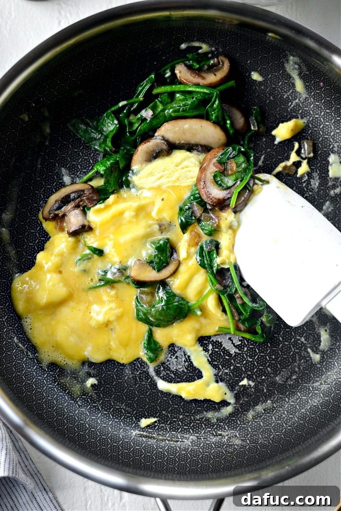 Vibrant Spinach and Mushroom Scramble 13 Use a spatula to gently stir and fold the eggs until almost fully cooked