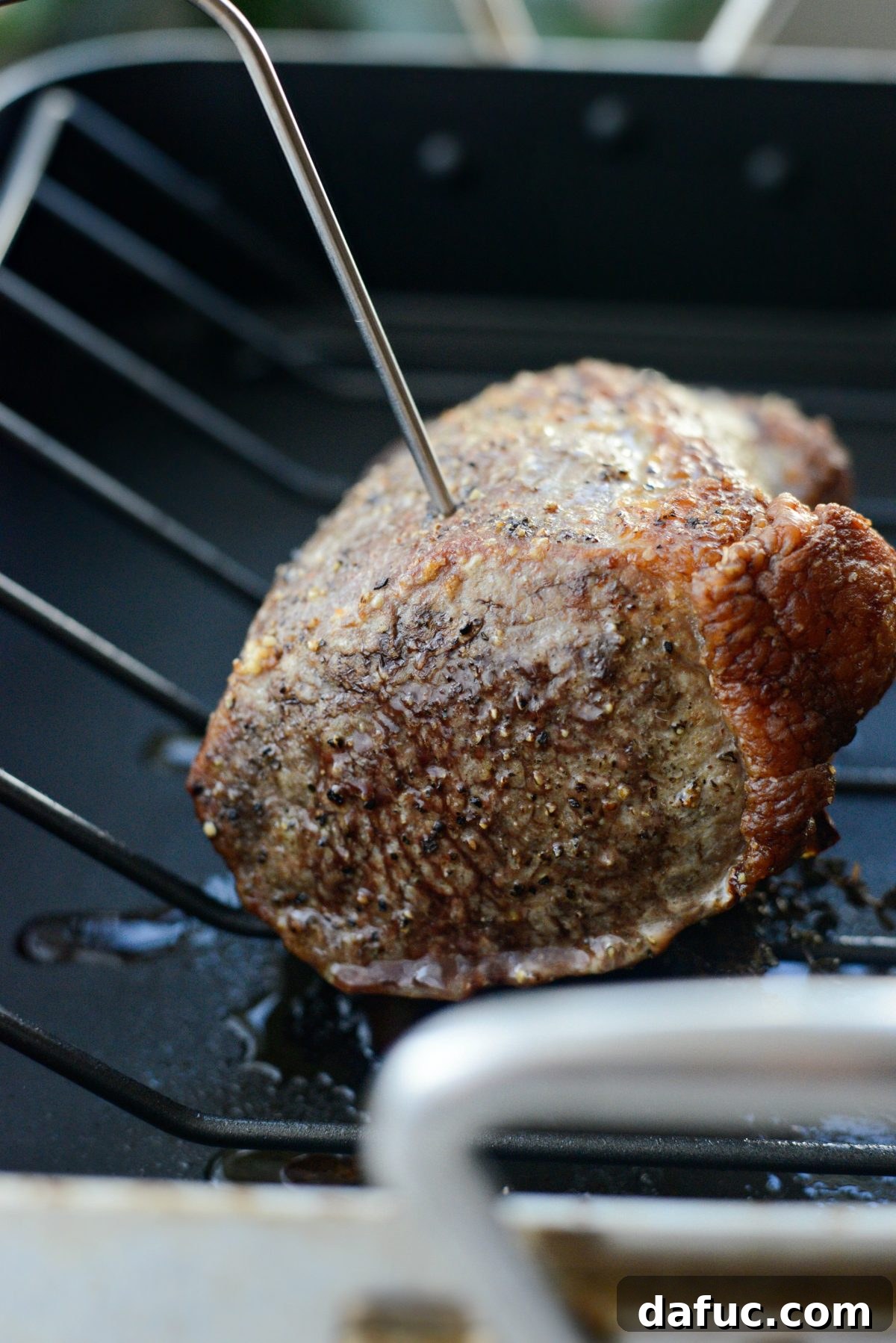 The beef roast cooking in the oven, achieving a perfect sear.