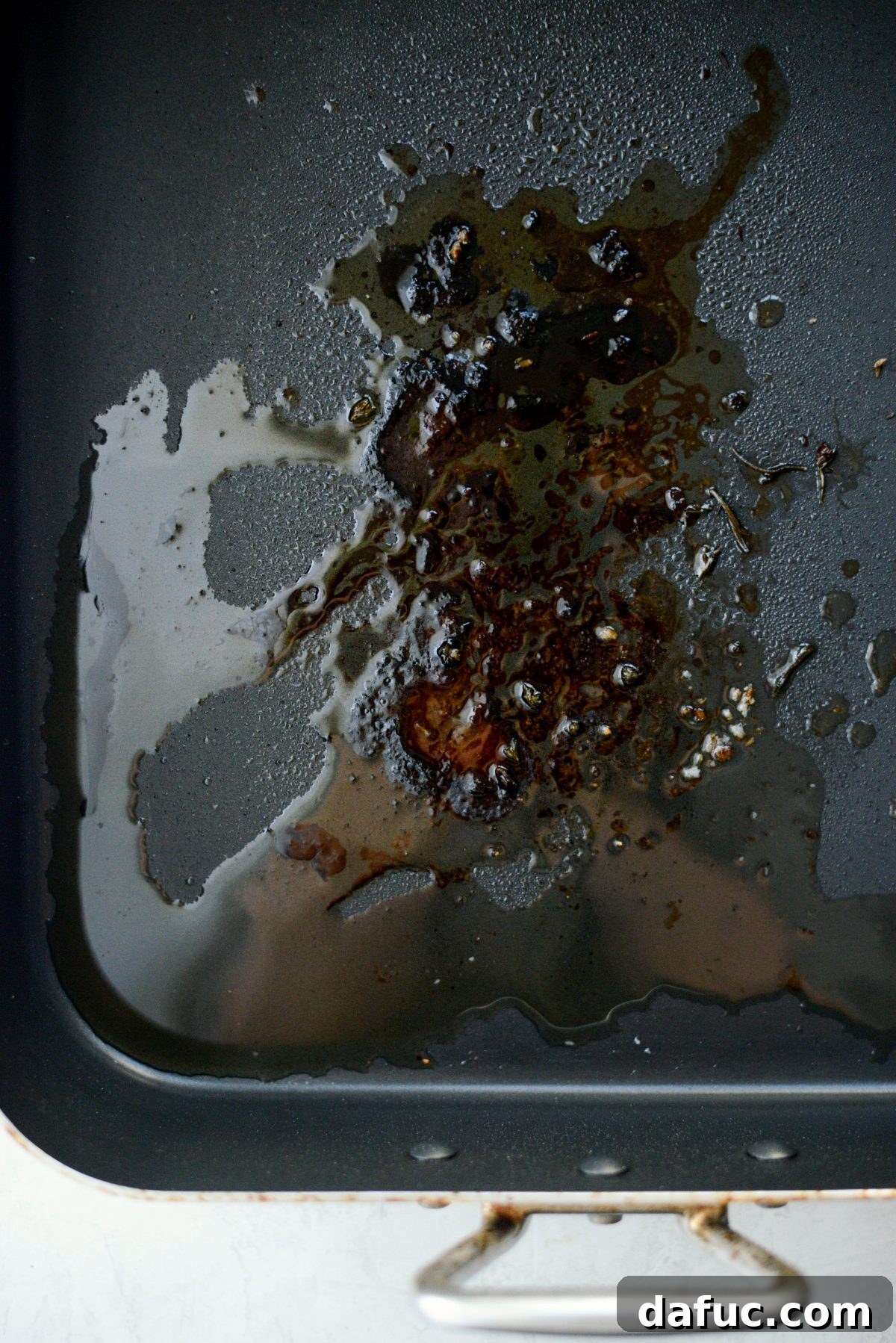Preparing the savory au jus in the roasting pan on the stovetop.