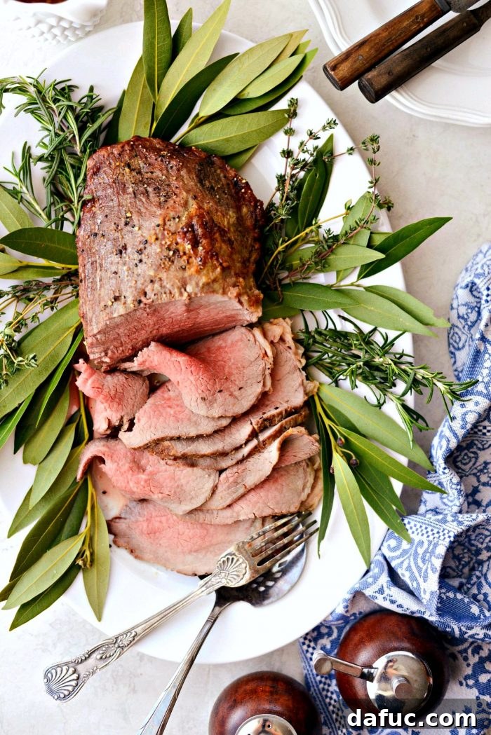 A stunning platter of Homemade Roast Beef with Au Jus, ready to serve.