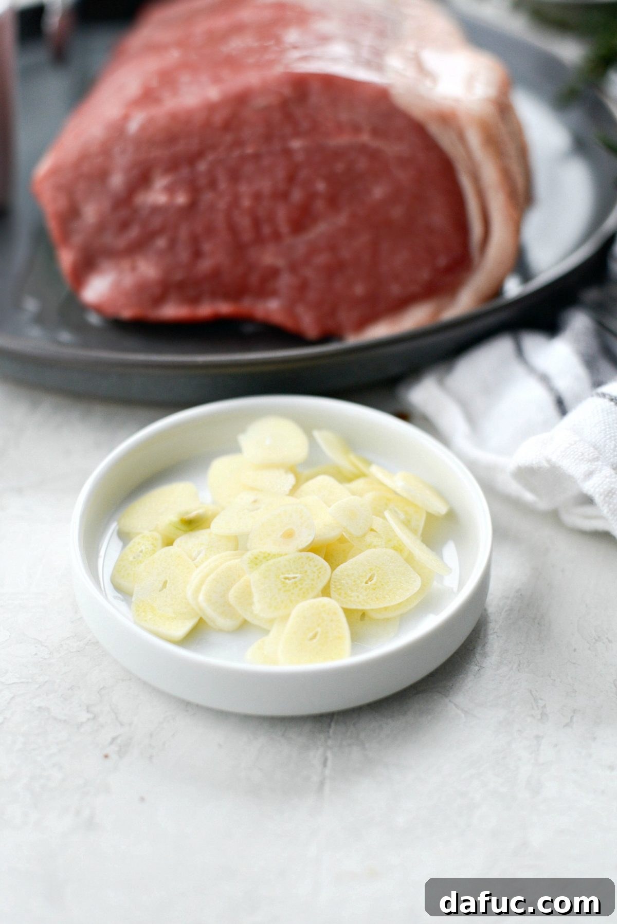 Thinly sliced garlic cloves ready for insertion into the roast.