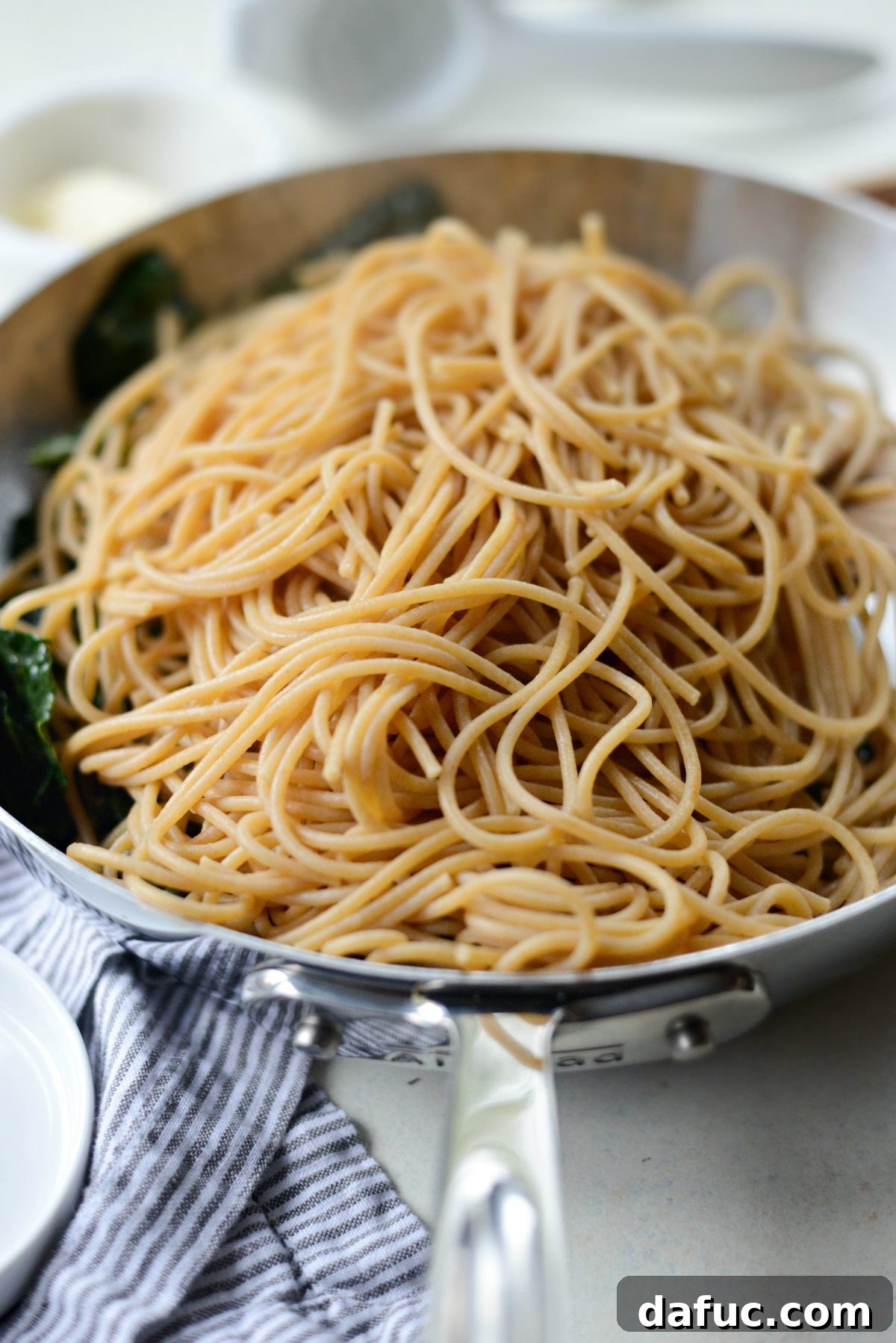 Tangy Lemon Kale Spaghetti with Olives and Parmesan 13 Adding cooked spaghetti to kale mixture