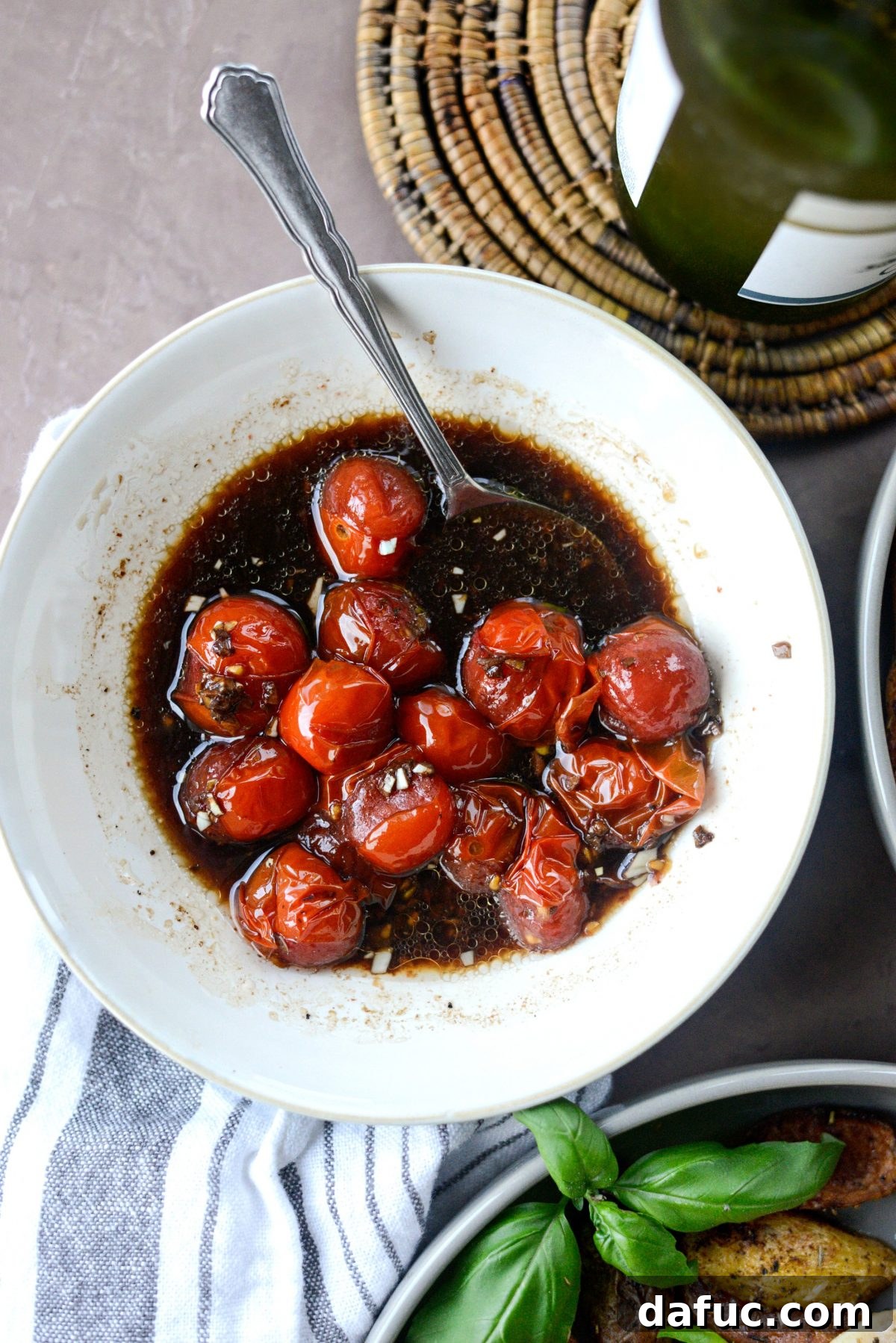 Transferring roasted balsamic tomatoes to a serving bowl
