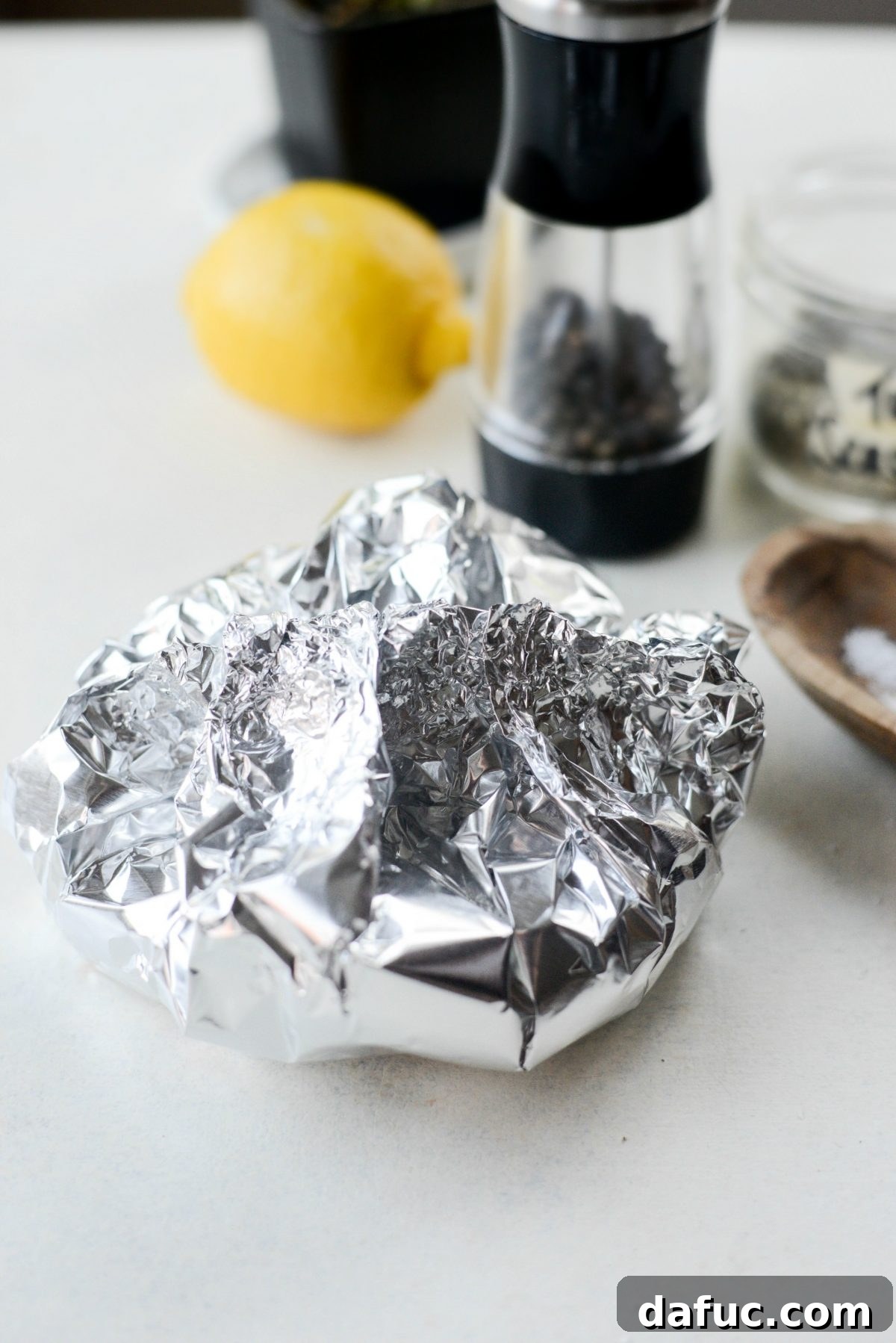 Crimping aluminum foil to create a sealed pouch for roasting tomatoes
