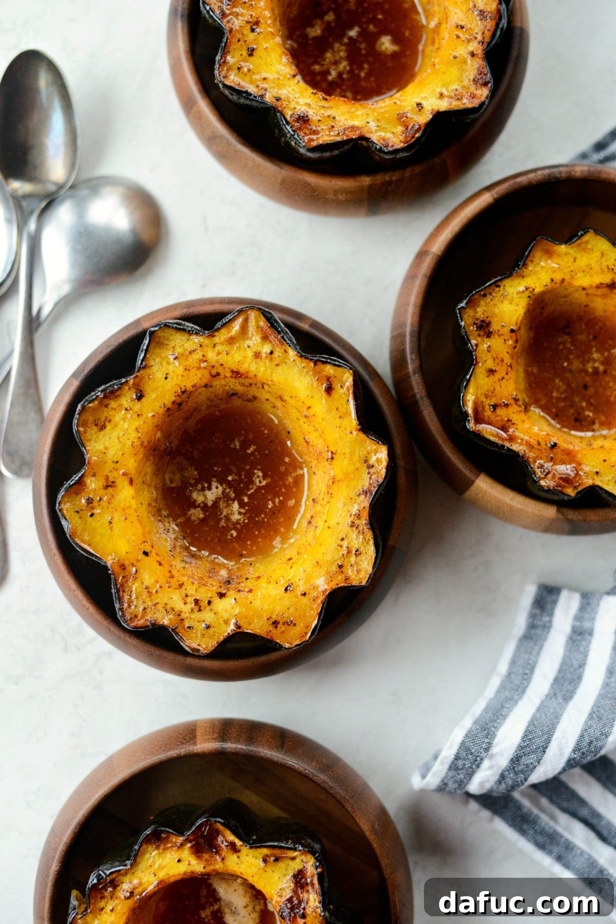 A close-up of a maple butter roasted acorn squash half, showing its caramelized edges and spoon-tender interior.
