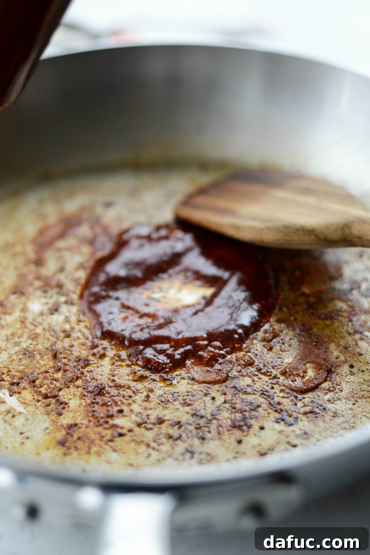 Cheesy Skillet Monterey Chicken 8 Pouring barbecue sauce into the skillet to deglaze