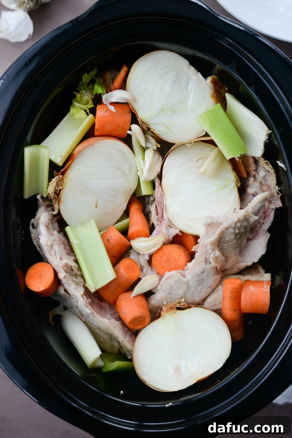 Veggies added to slow cooker with turkey bones