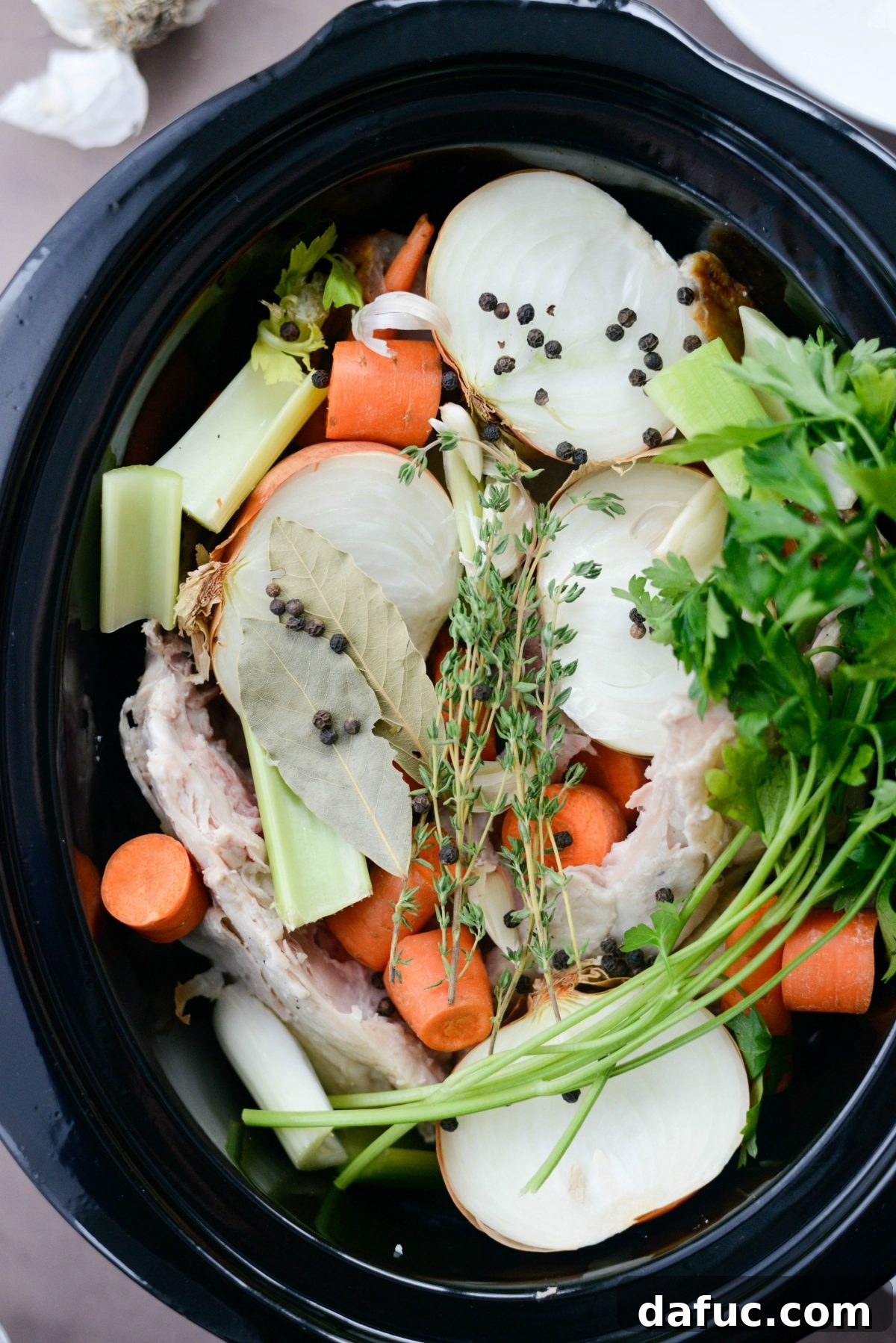 Herbs and peppercorns added to slow cooker