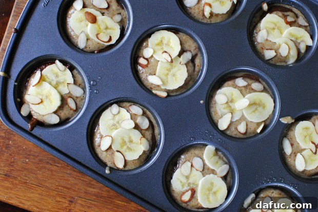 Almond Banana Muffins topped with banana slices and sliced almonds, ready for baking