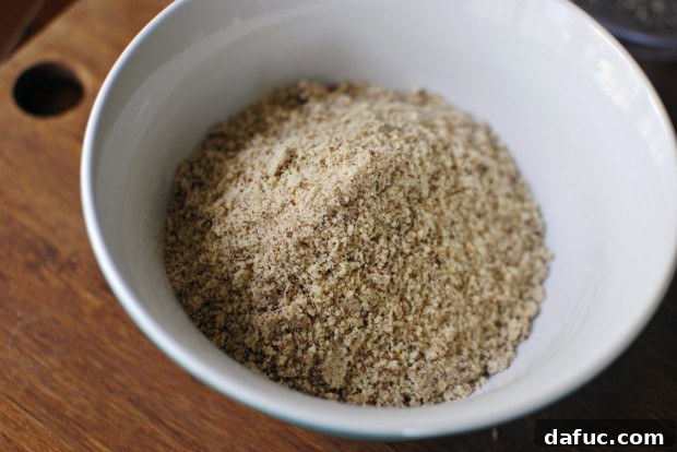 Finely ground almond meal being poured into a large mixing bowl