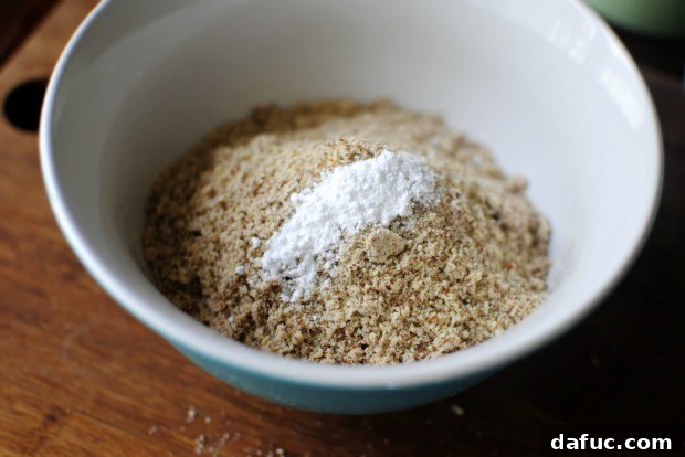 Adding baking powder to the almond meal in a mixing bowl