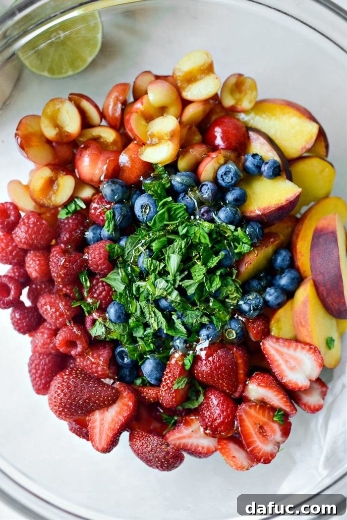 Adding freshly torn mint and basil leaves along with a generous drizzle of honey into the fruit mixture