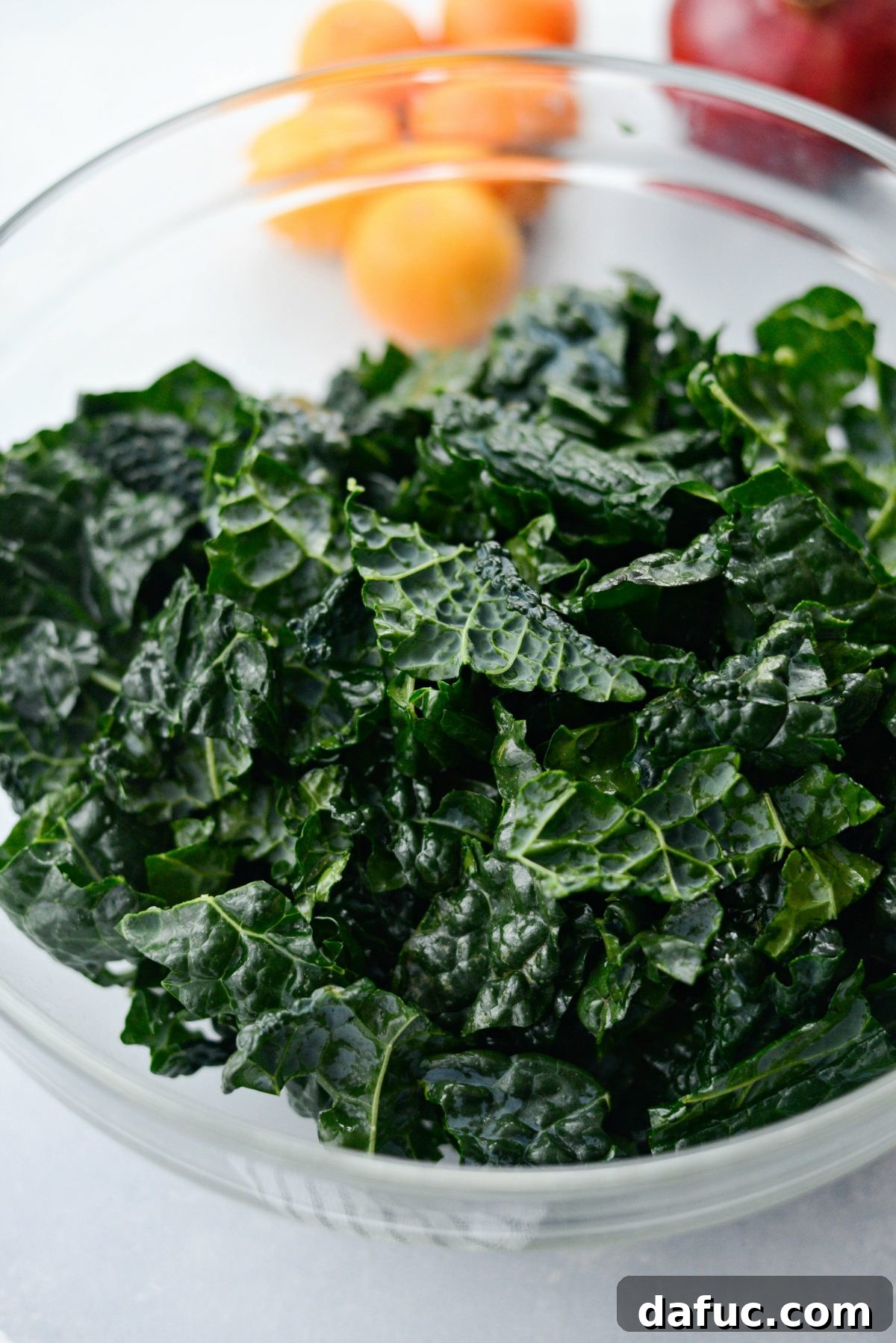 Prepared lacinato kale leaves in a bowl with olive oil and salt