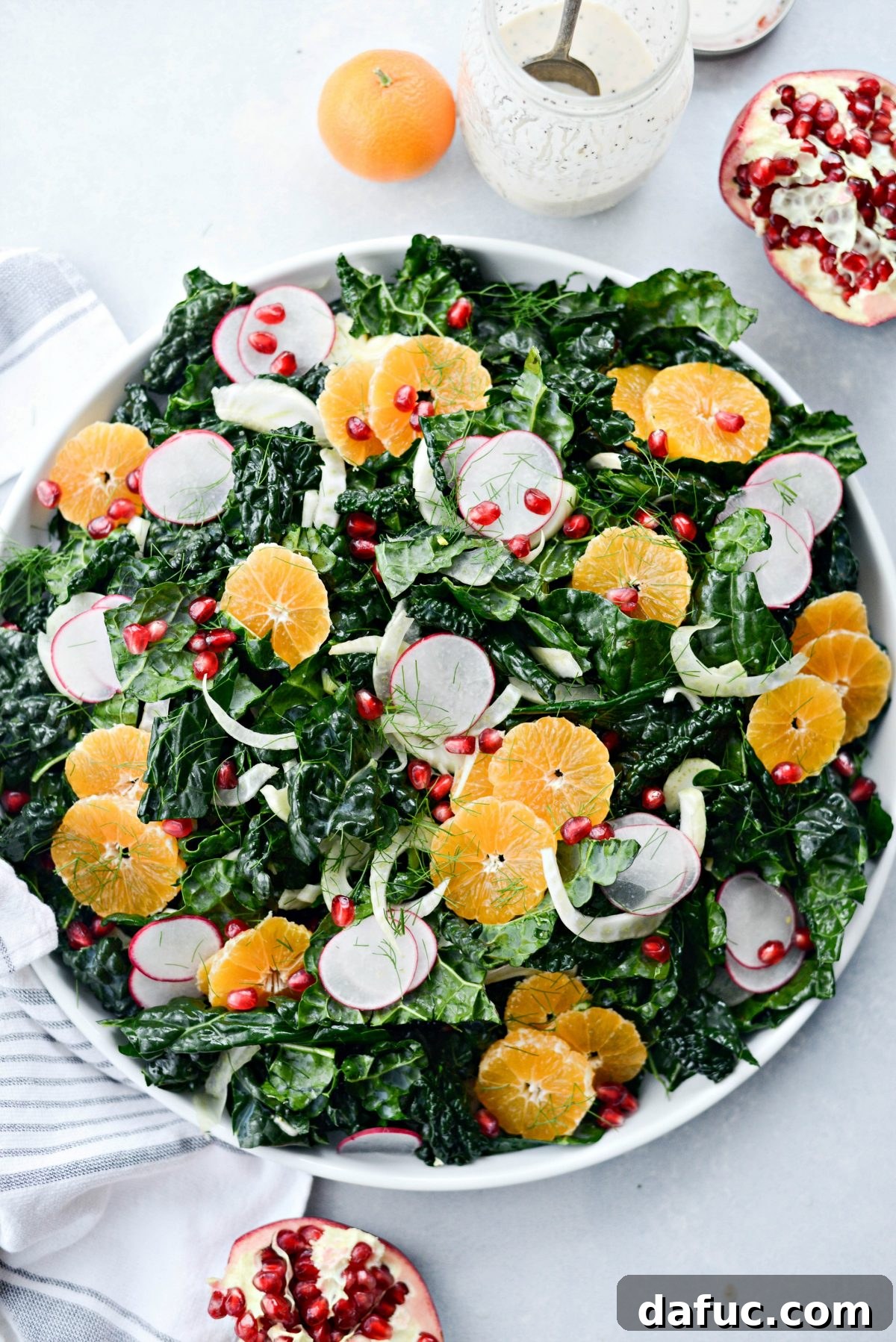 Building Winter Clementine Fennel and Kale Salad with layers of ingredients
