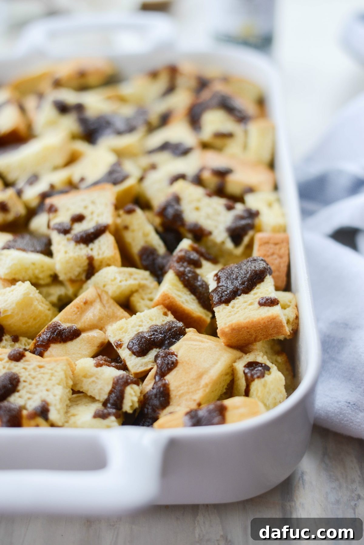 Drizzling gingerbread topping over soaked brioche