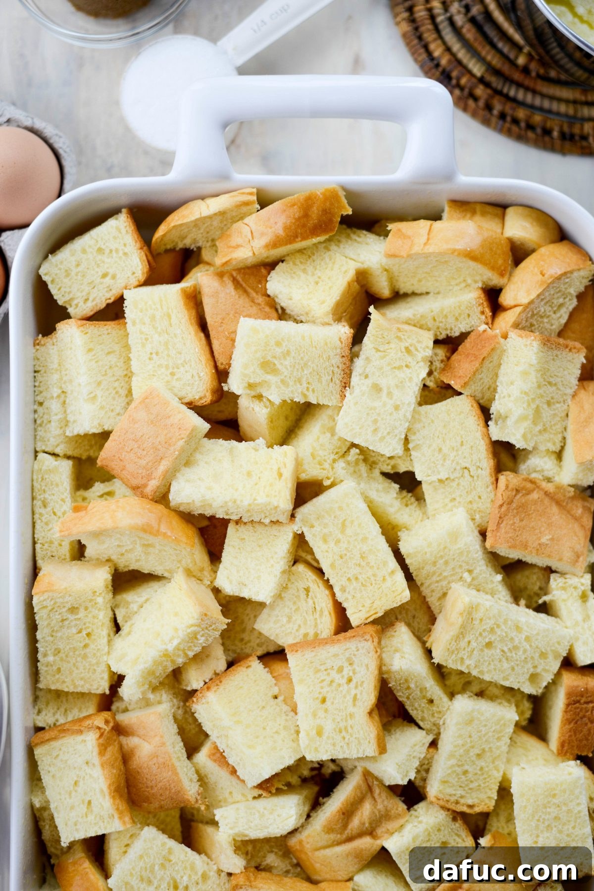Adding cubed brioche to a casserole dish