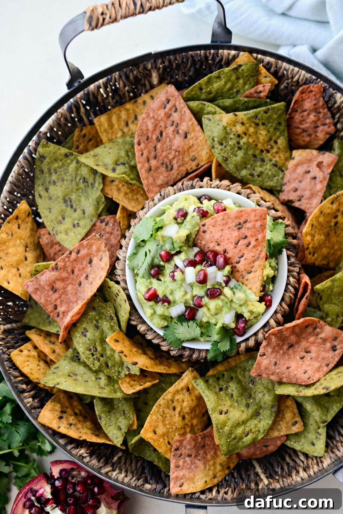 Vibrant Holiday Guacamole with pomegranate seeds and festive chips