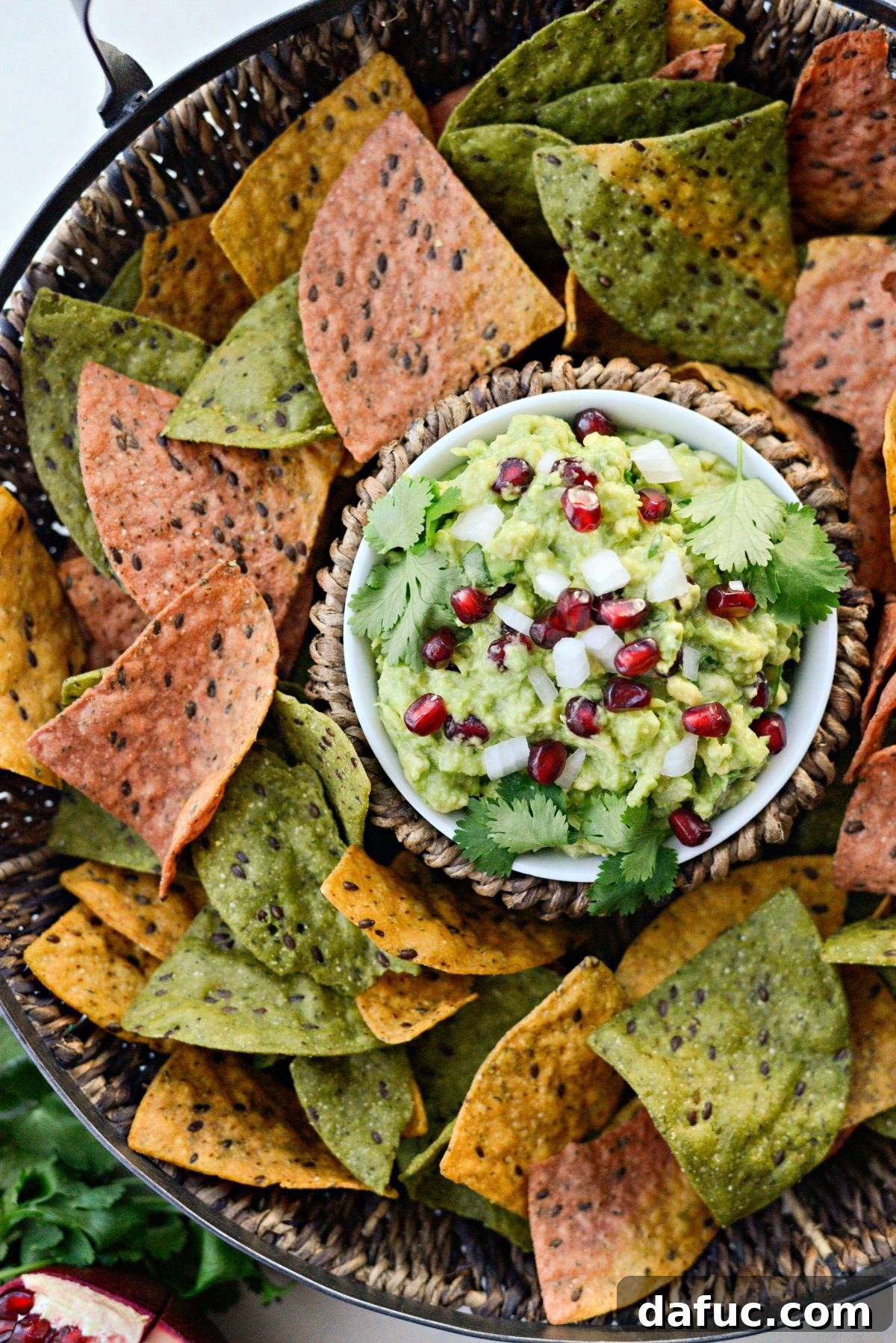 Holiday Guacamole served in a bowl with colorful tortilla chips