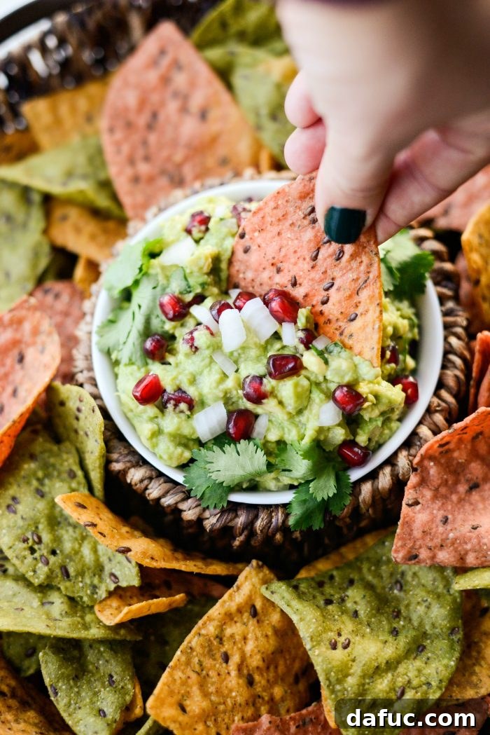 Close-up view of Holiday Guacamole with colorful chips in the background