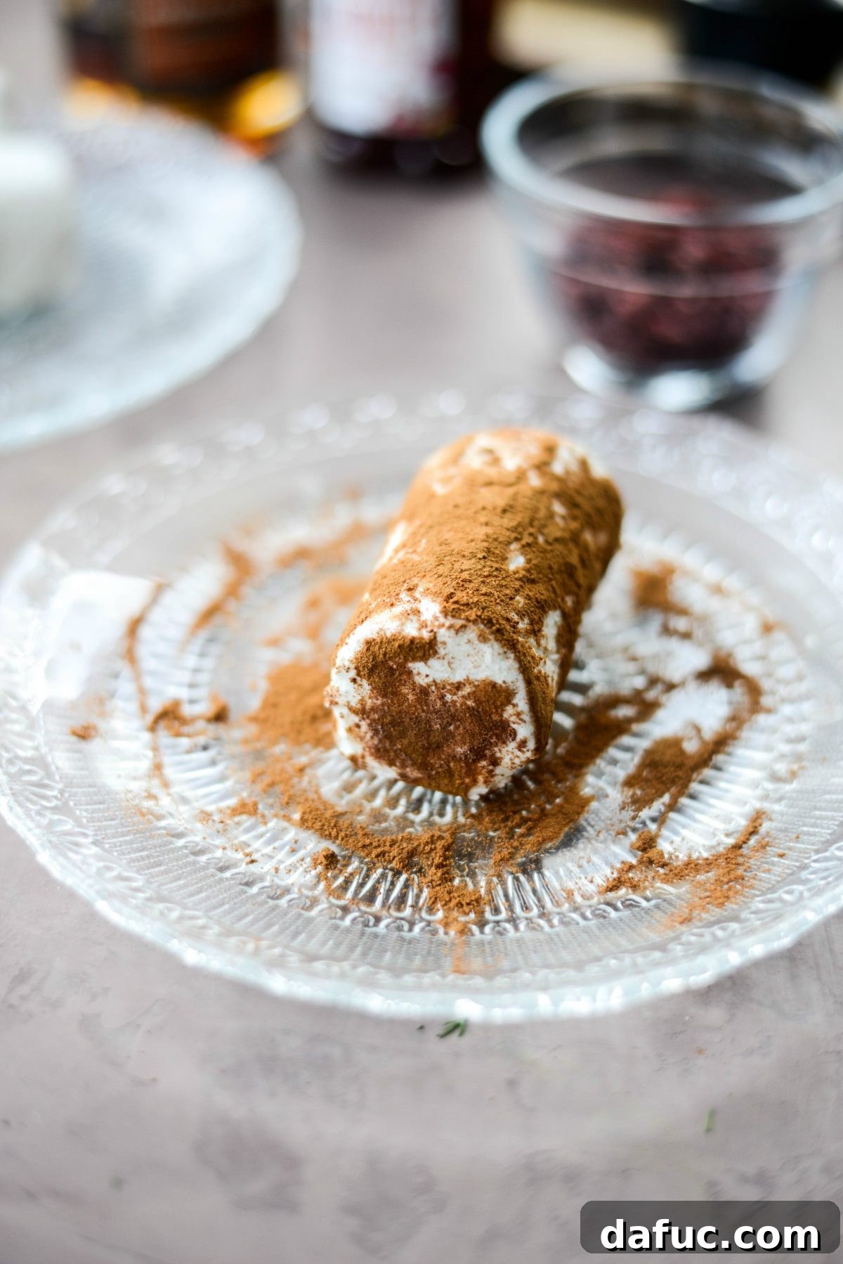 Goat cheese log being rolled in cinnamon and nutmeg