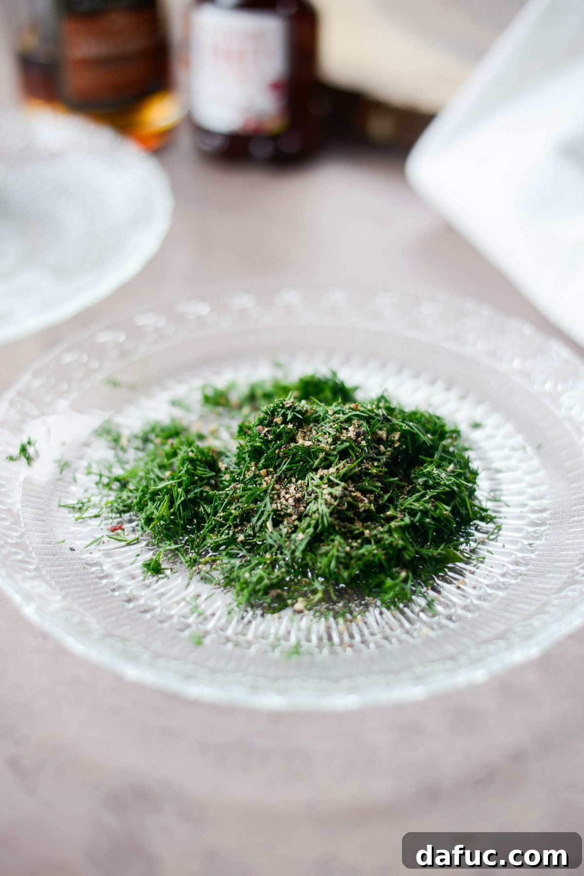 Fresh dill and coarsely ground black pepper on a shallow plate