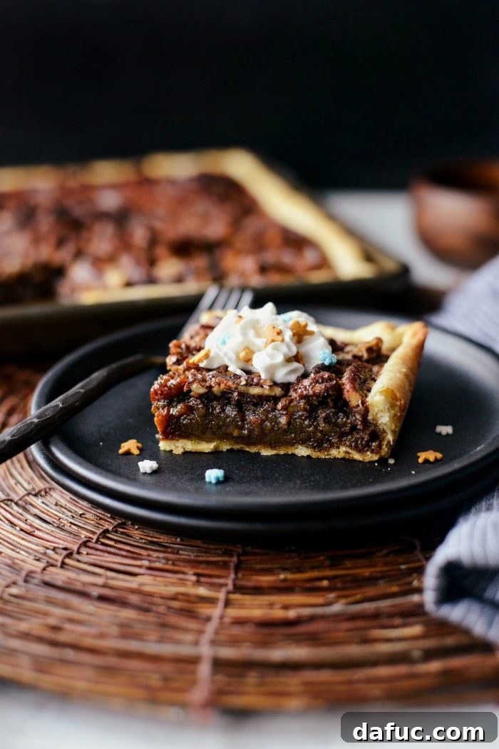Gingerbread Pecan Slab Pie on a plate, topped with a dollop of whipped cream