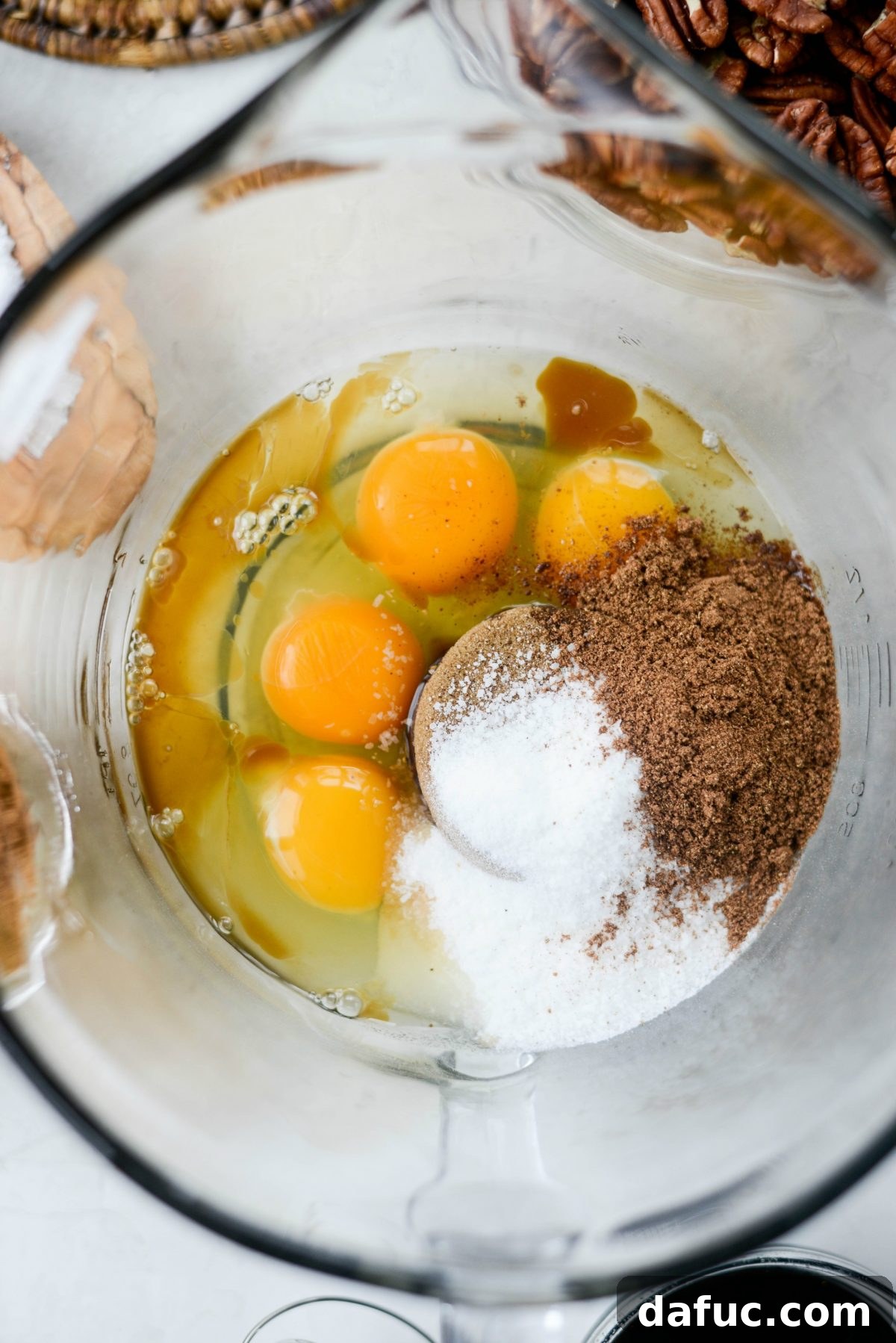 Eggs, sugar, and gingerbread spices in a mixing bowl, ready to be whisked