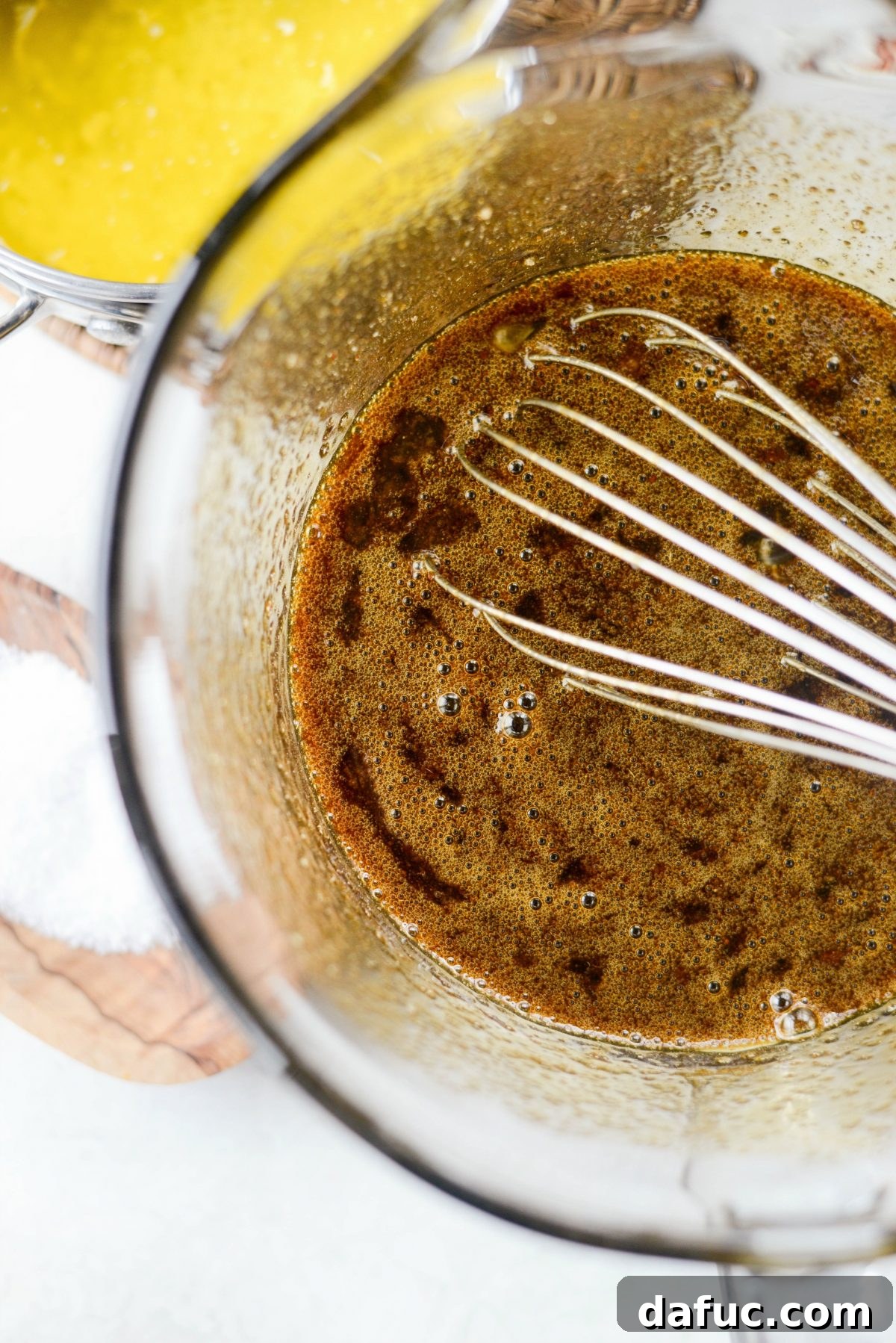 Whisking eggs, sugars, and spices in a bowl