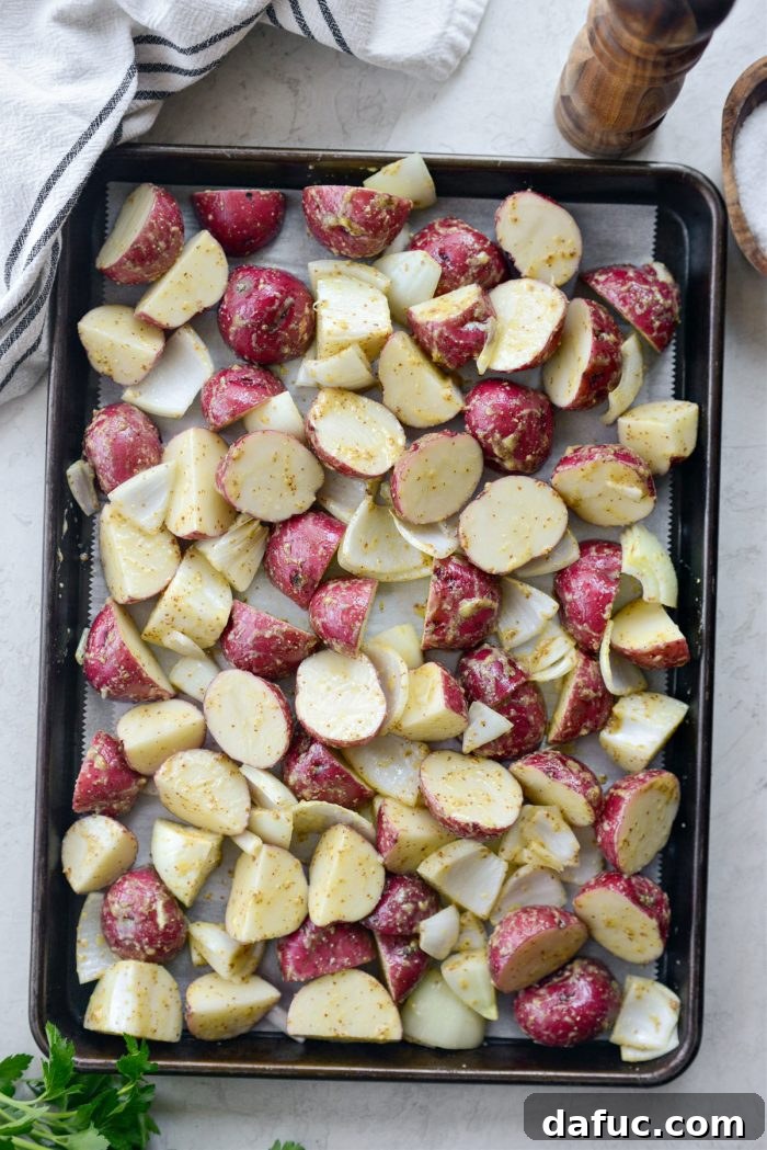 Zesty Dijon Roasted Redskin Potatoes 9 spread onions and potatoes onto parchment paper lined sheet pan