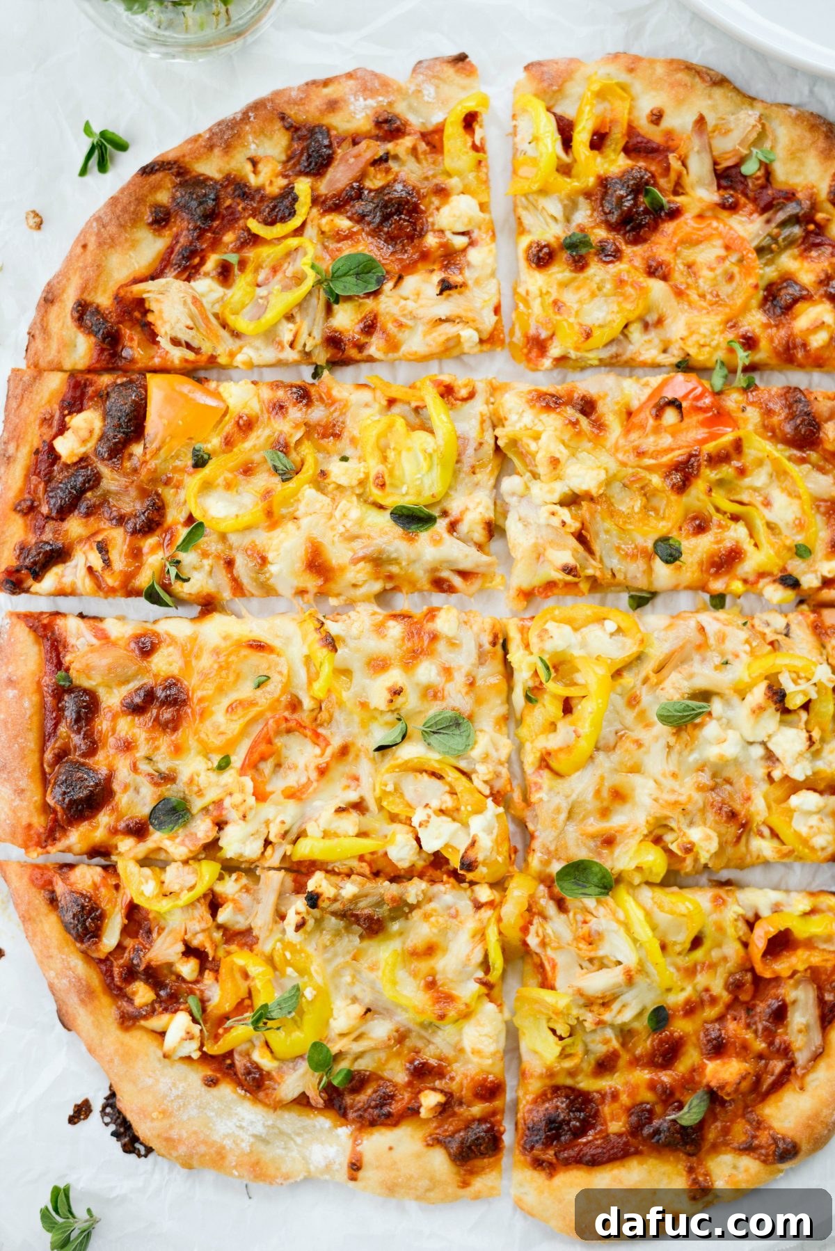 Close-up of three slices of Spicy Chicken Feta Pizza on a serving board, showcasing the delicious toppings