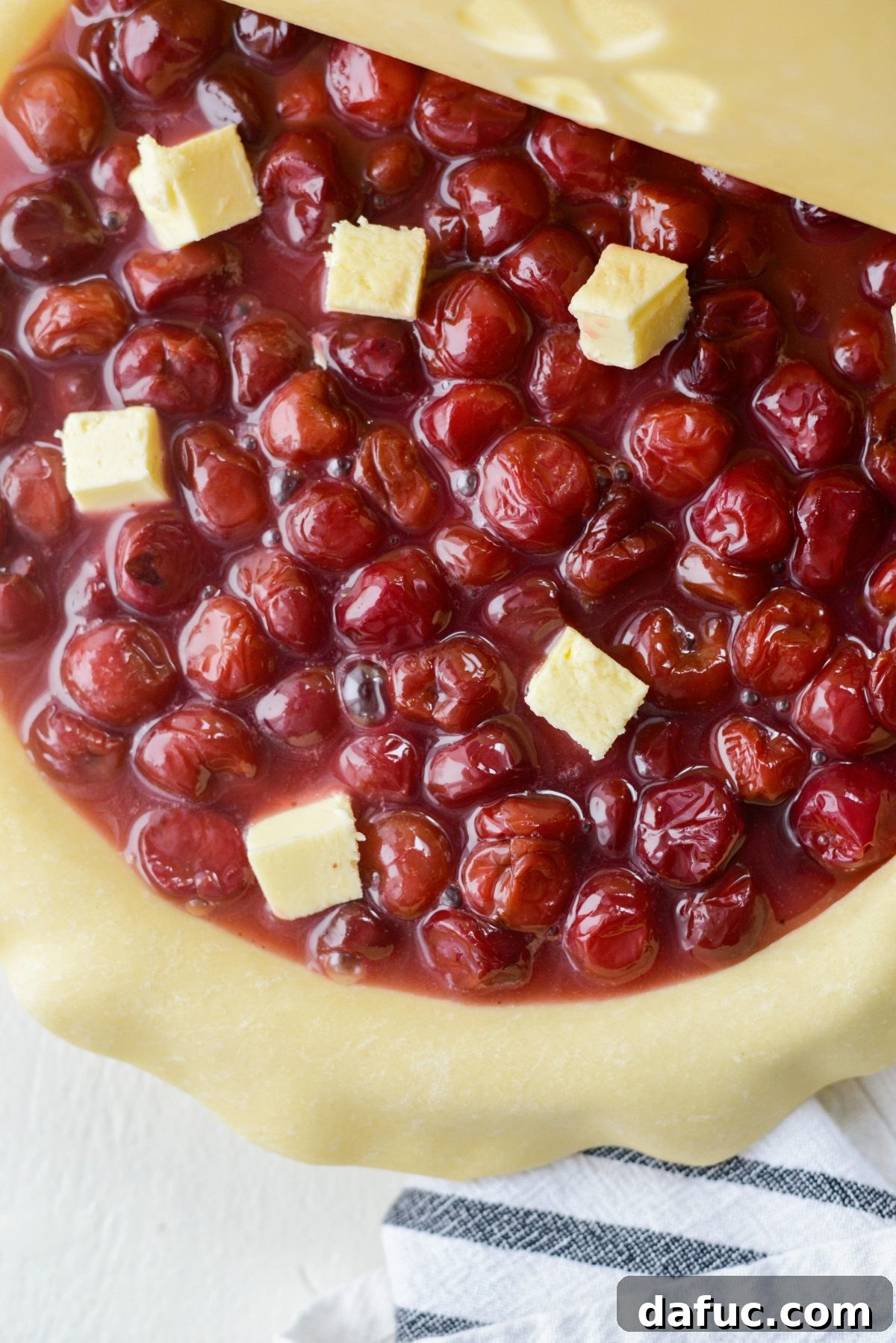 Dotting cherry pie with butter