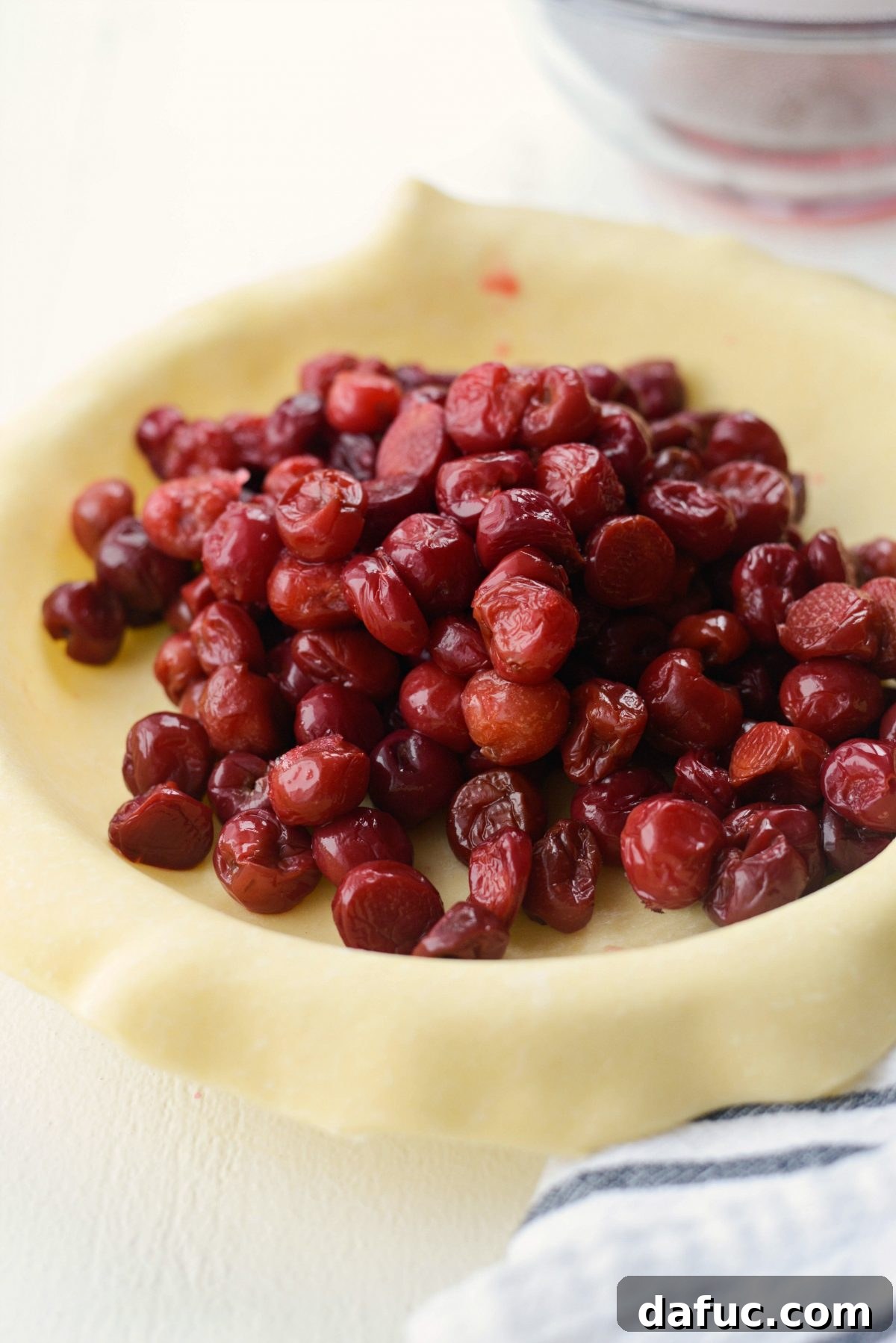 Adding drained cherries to the pie crust