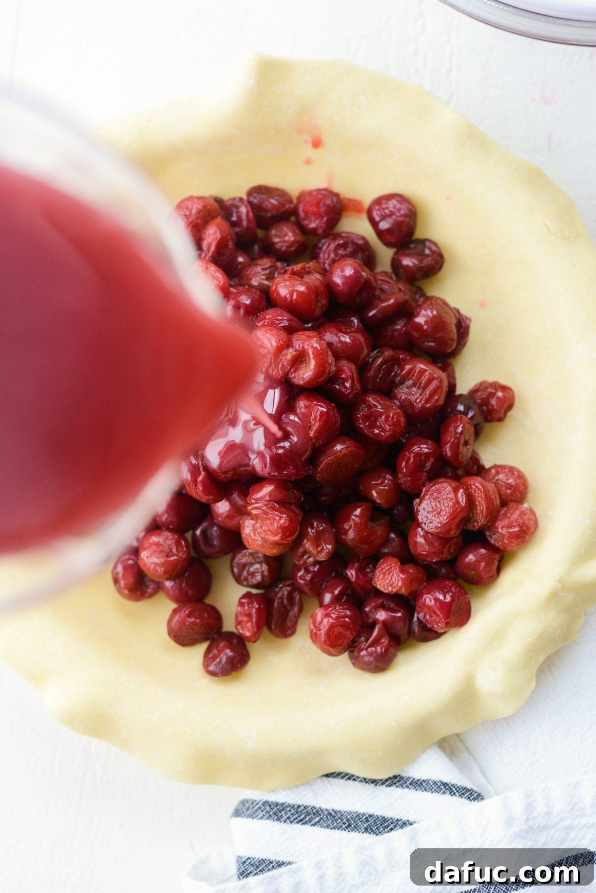 Pouring in thickened cherry pie filling