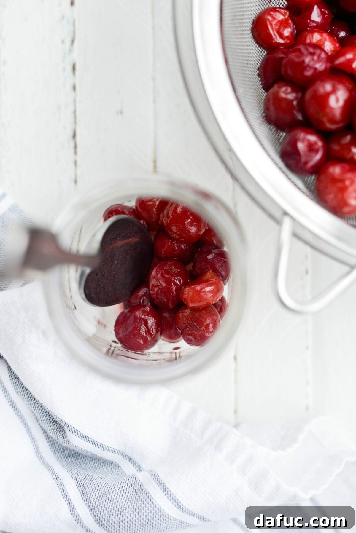 Naturally Crafted Maraschino Cherries 11 Spooning cherries into a large glass jar