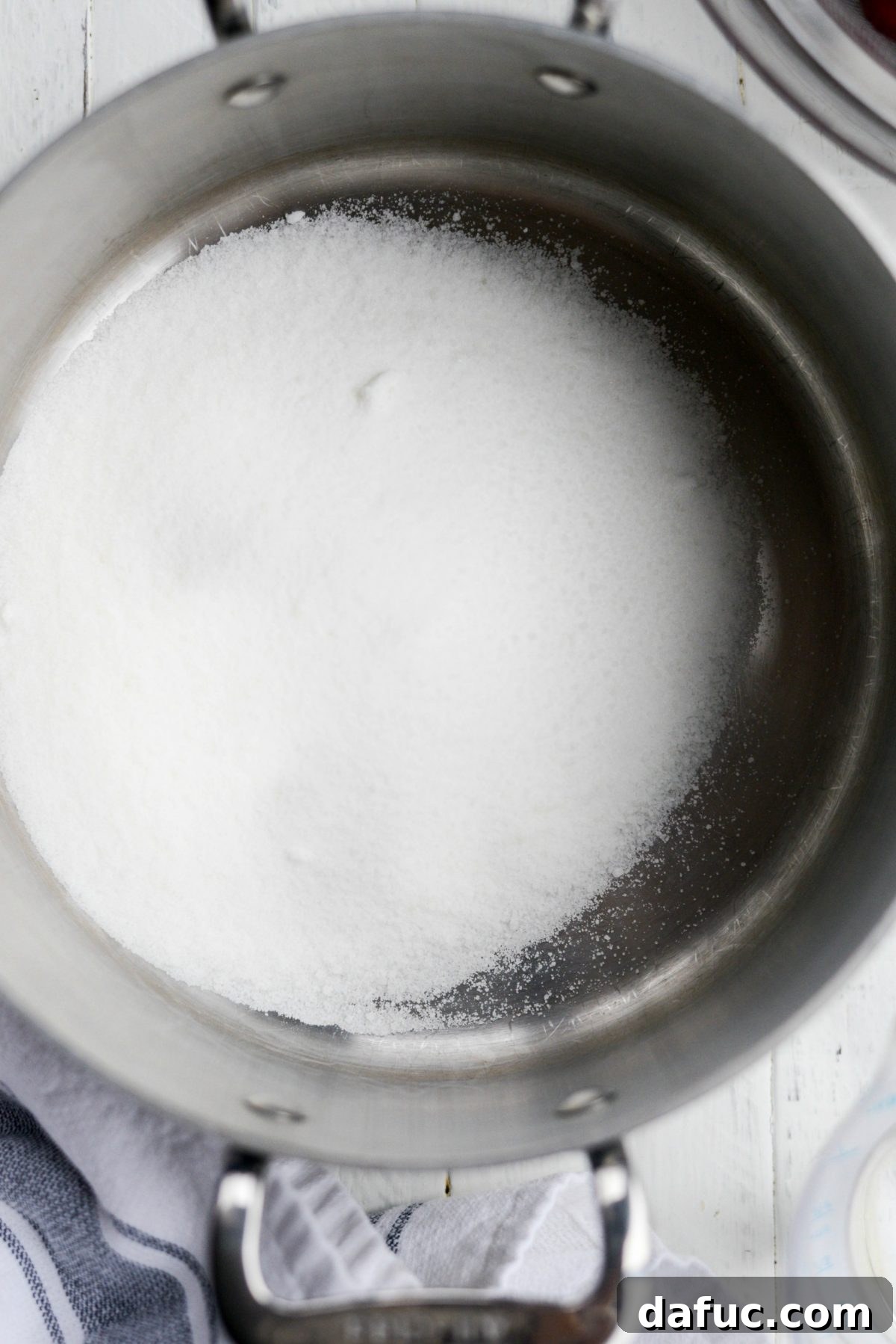 Naturally Crafted Maraschino Cherries 5 Sugar being added to a saucepan