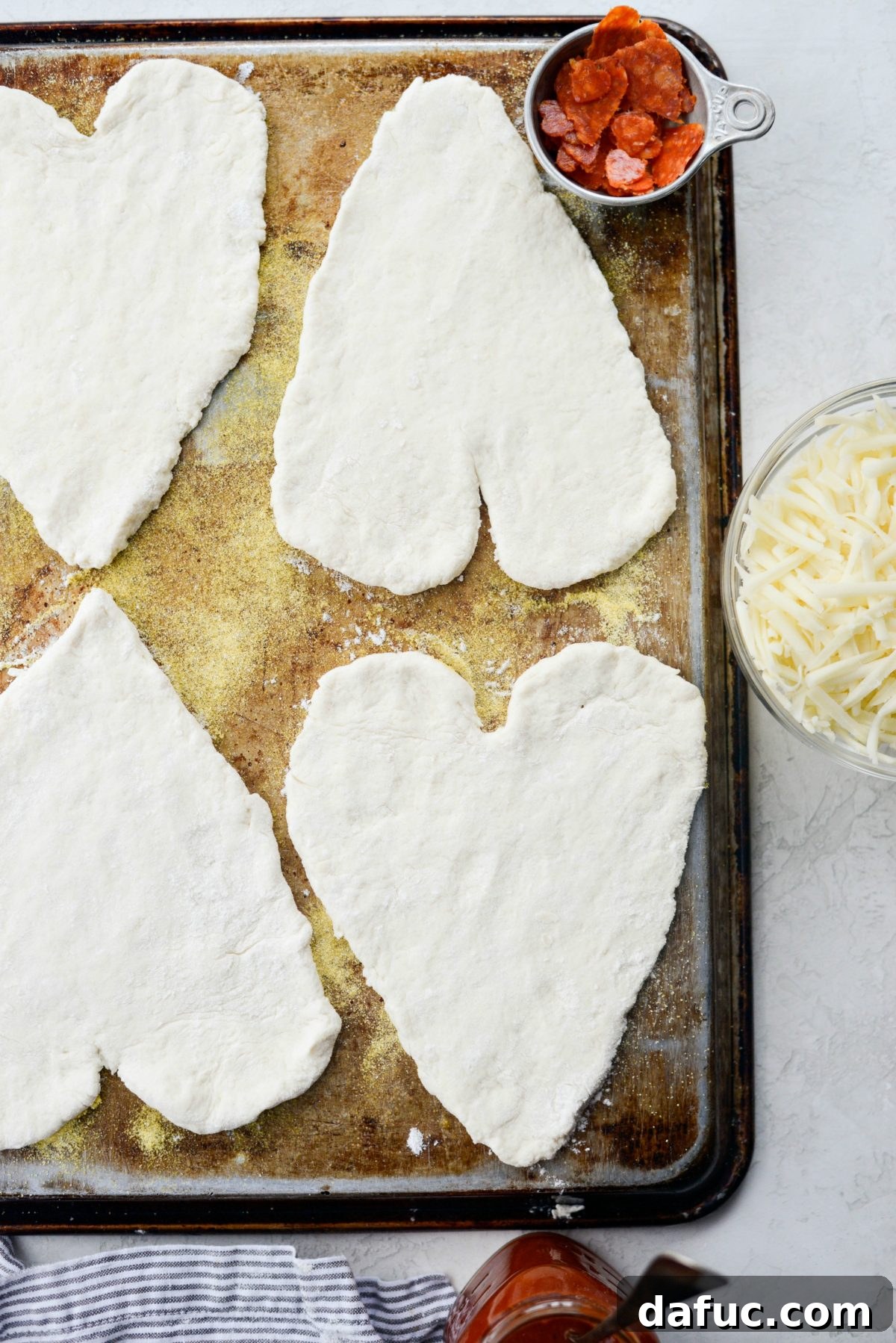 Sweetheart Pizza Treats 9 Heart shaped pizza dough placed on an inverted rimmed baking sheet for baking