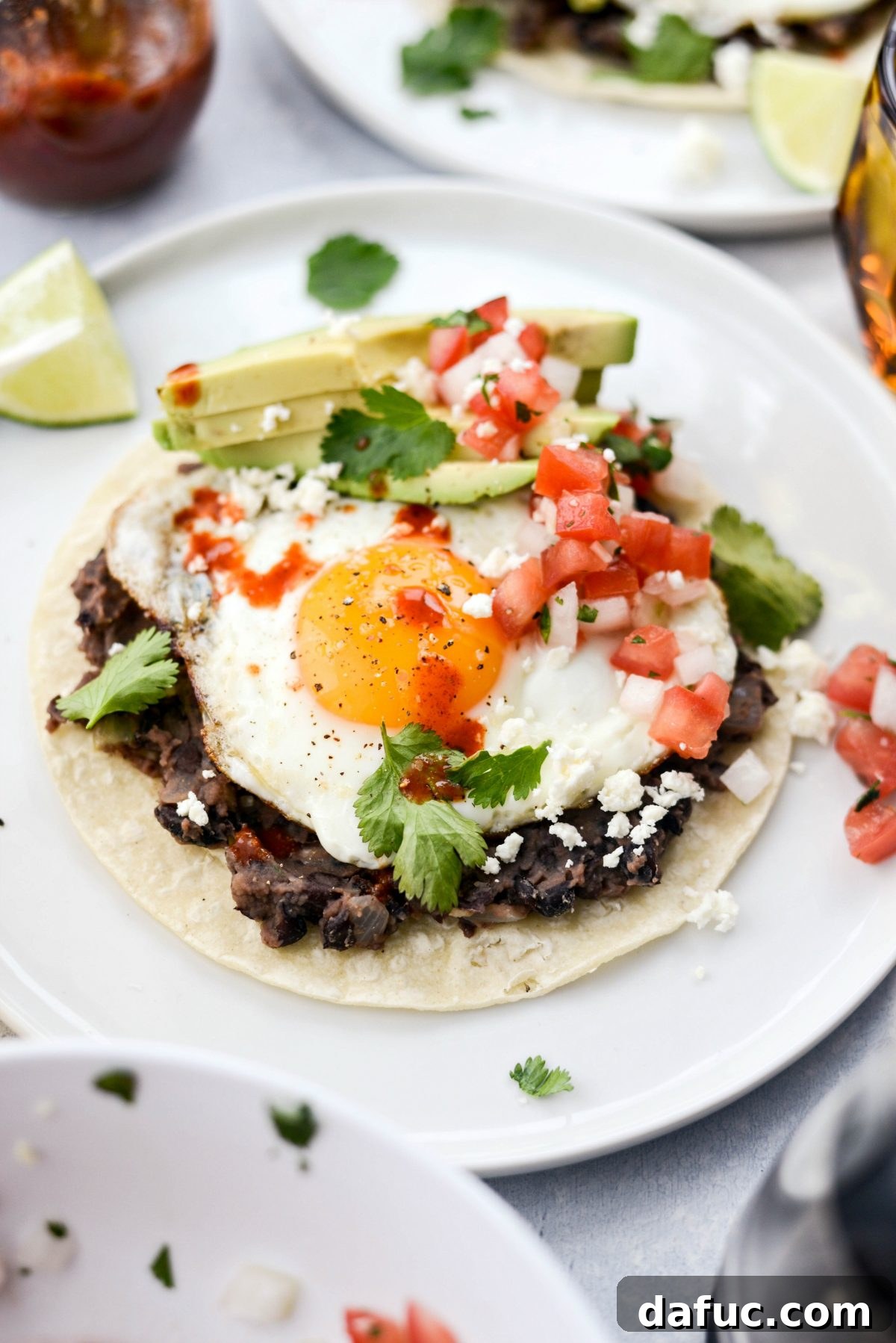 Close-up of a single serving of Huevos Rancheros on a white plate