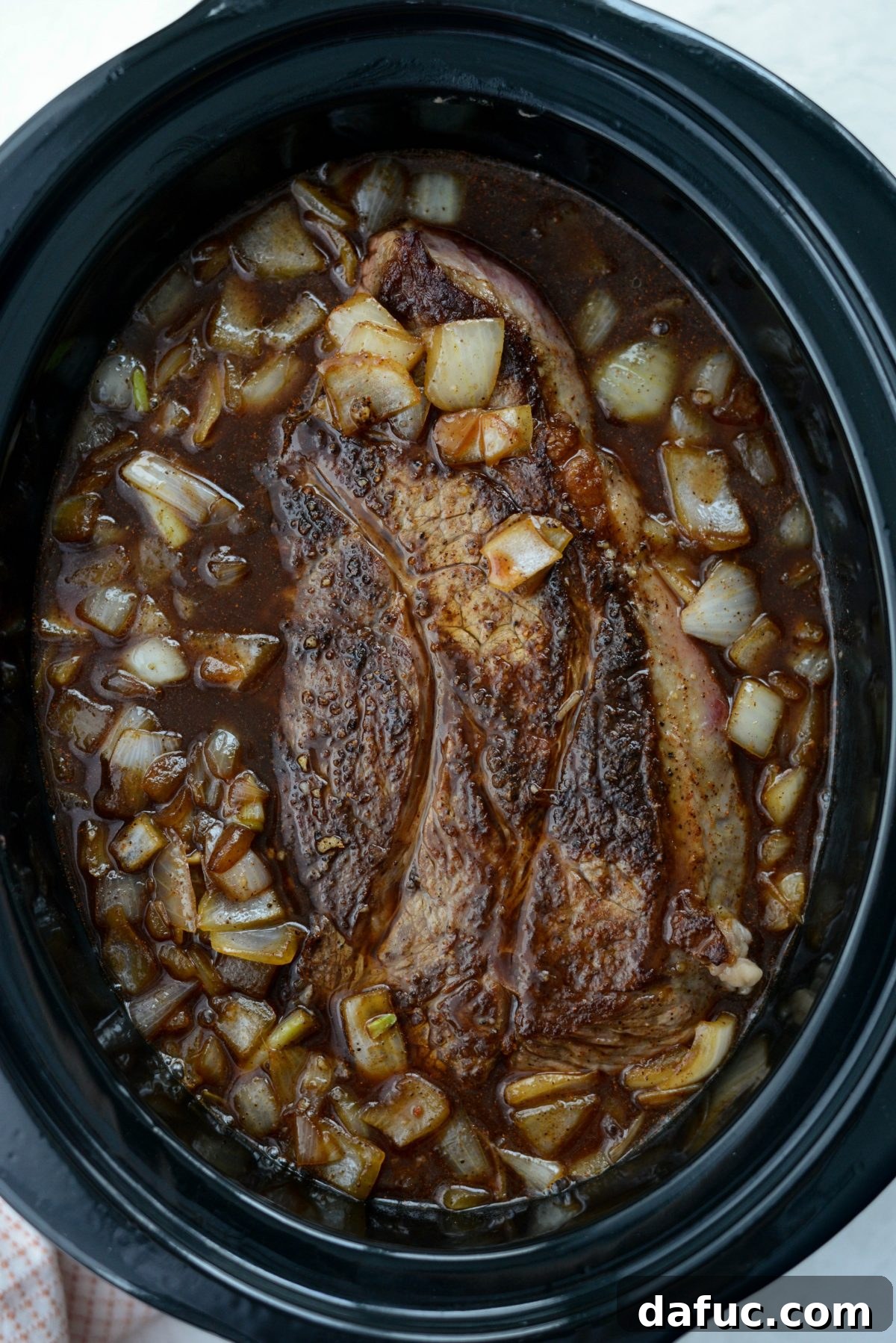 Fall-Apart Tender Slow Cooker Beef Barbacoa 12 The beef roast fully submerged in the aromatic cooking liquids, ready for the slow cooking process.